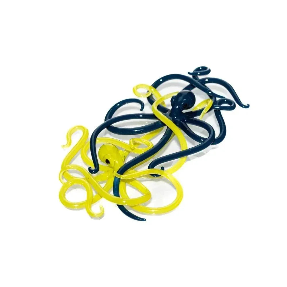 Handcrafted glass octopus sculpture in yellow and black on white background