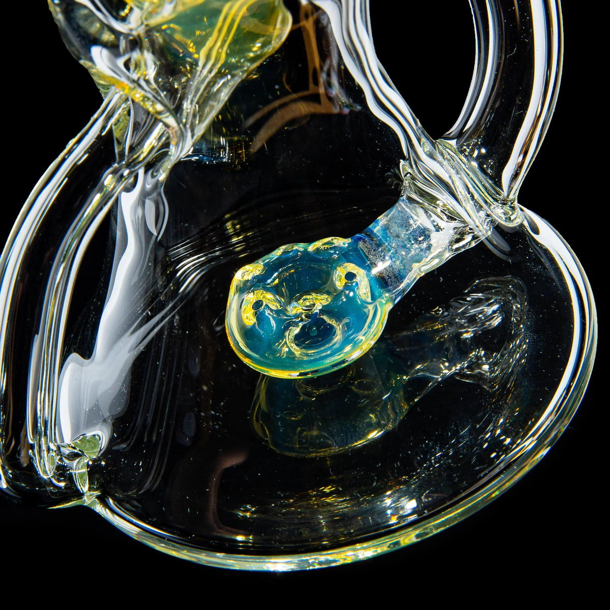 Close-up of intricate, colorful glass water pipe detail on black background