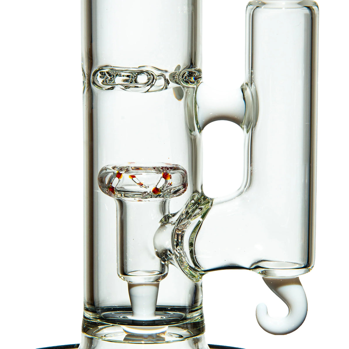 Close-up of a clear glass bong with intricate recycler and colored glass accents.