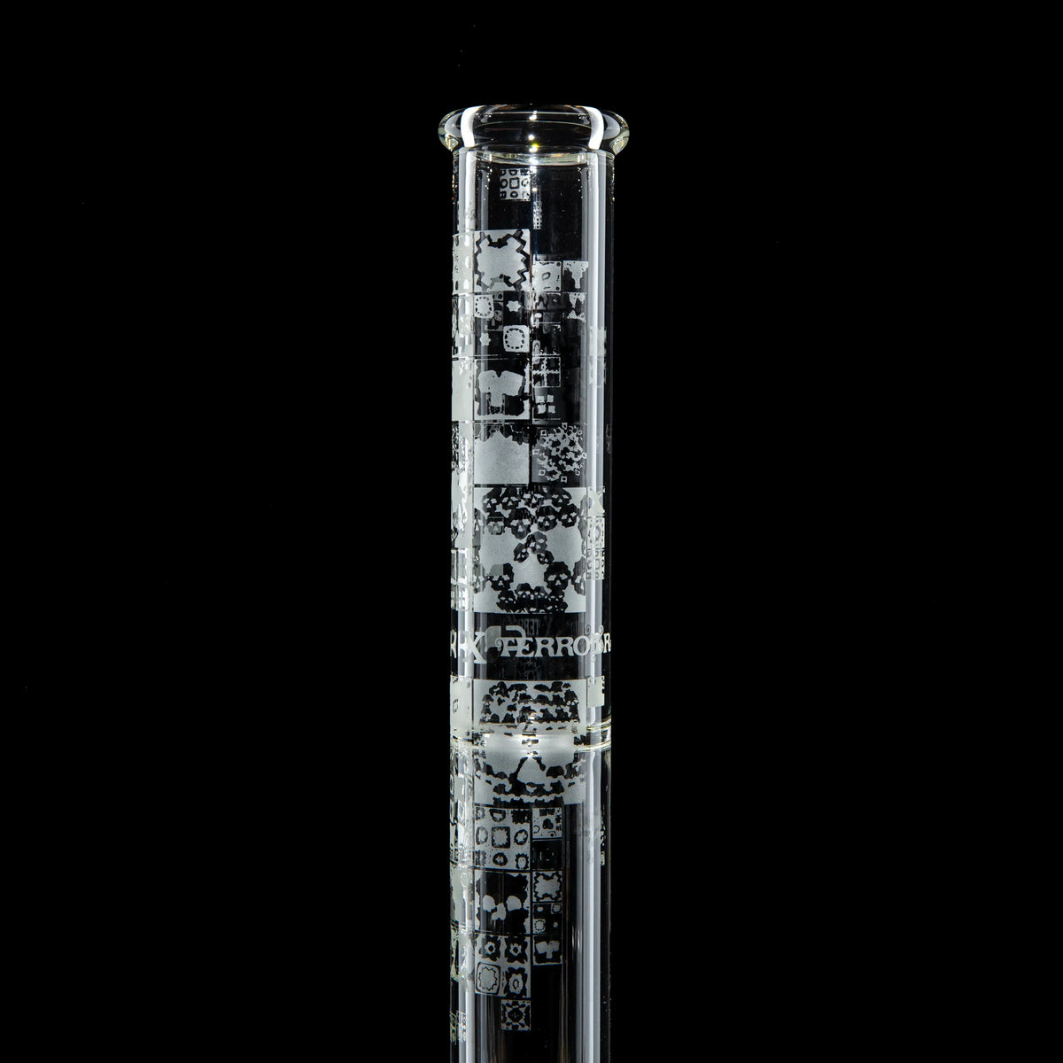 Clear glass tube with intricate etched patterns on a black background