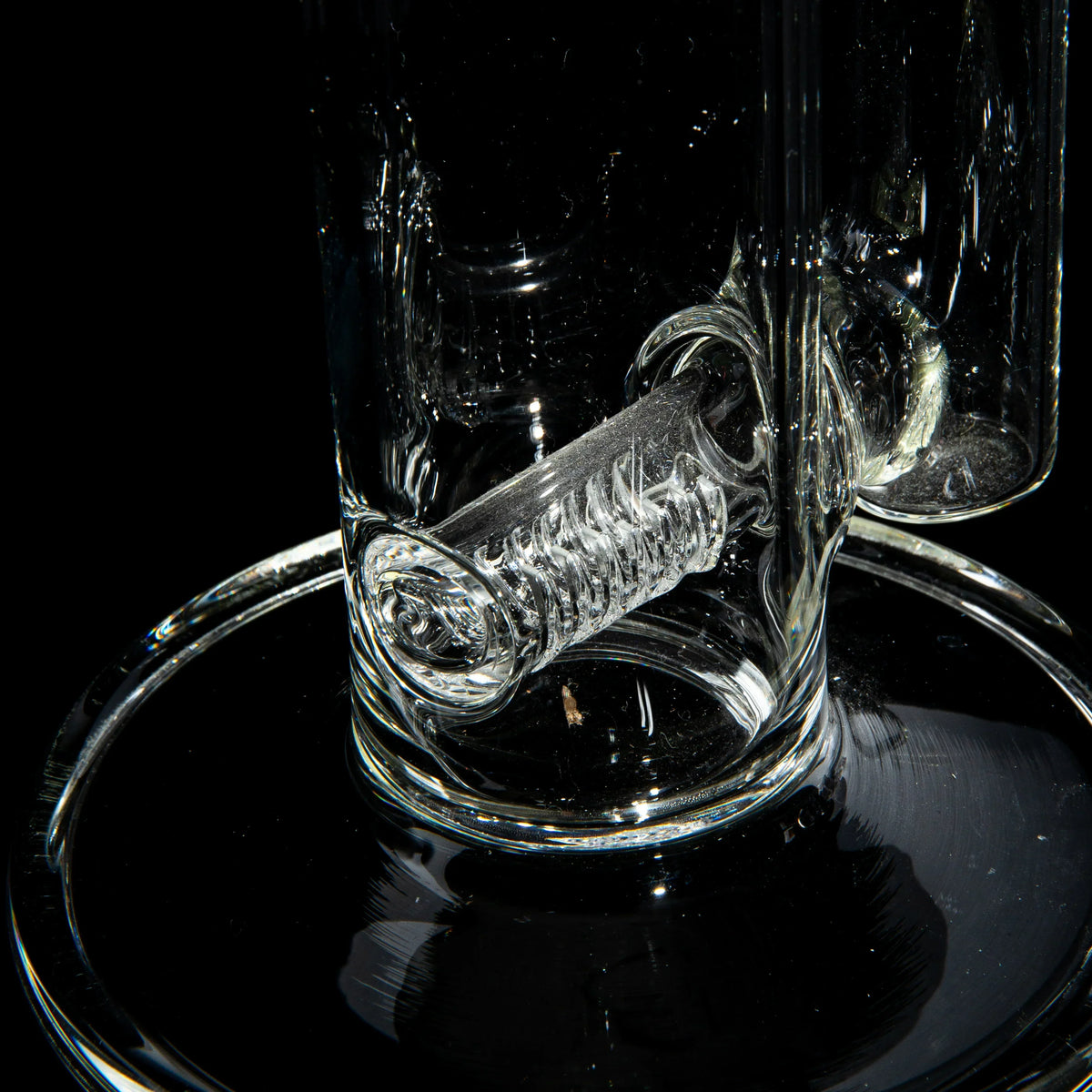 Close-up of intricate glass percolator in a clear water pipe on black background