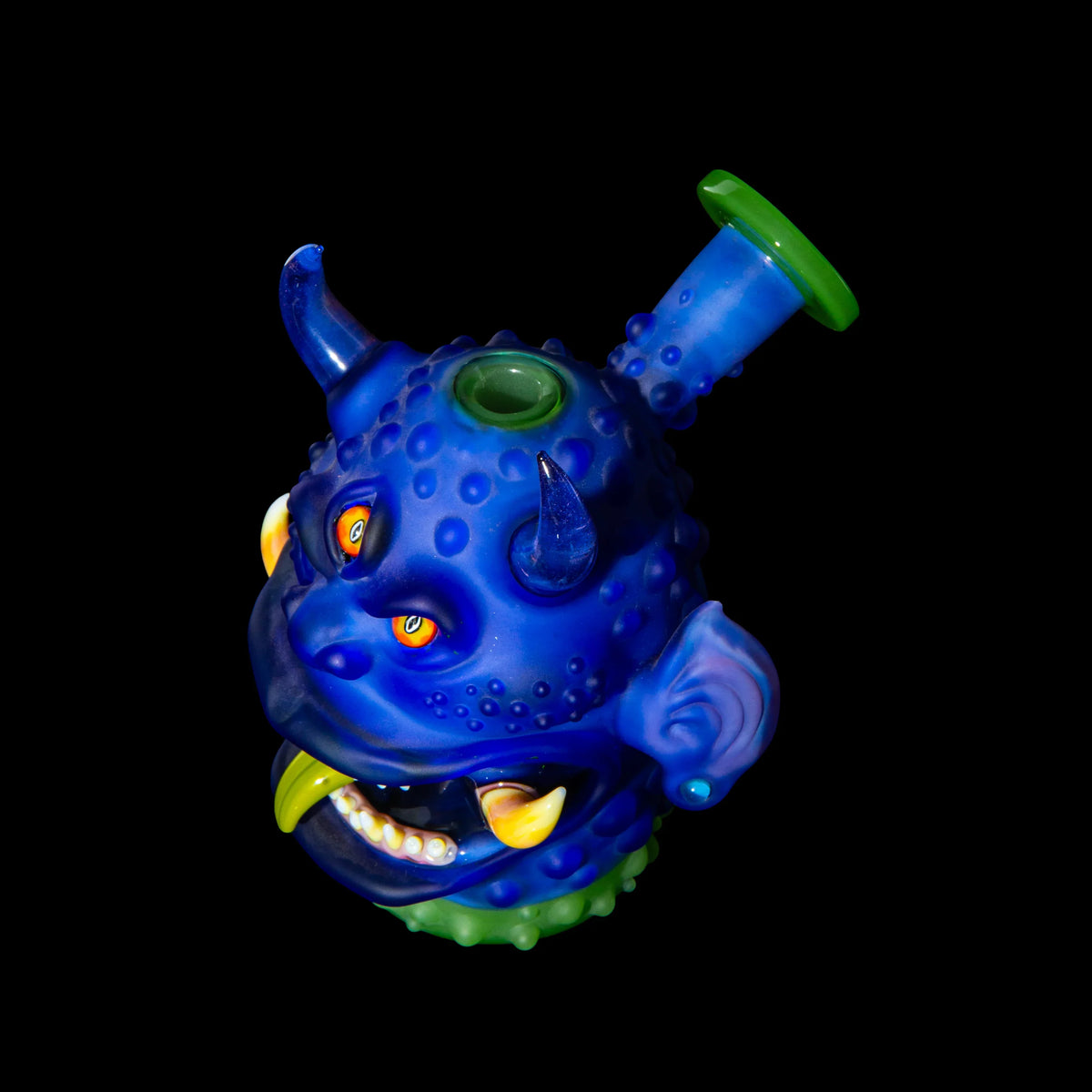 Blue glass monster head water pipe with horns and vibrant details on black background