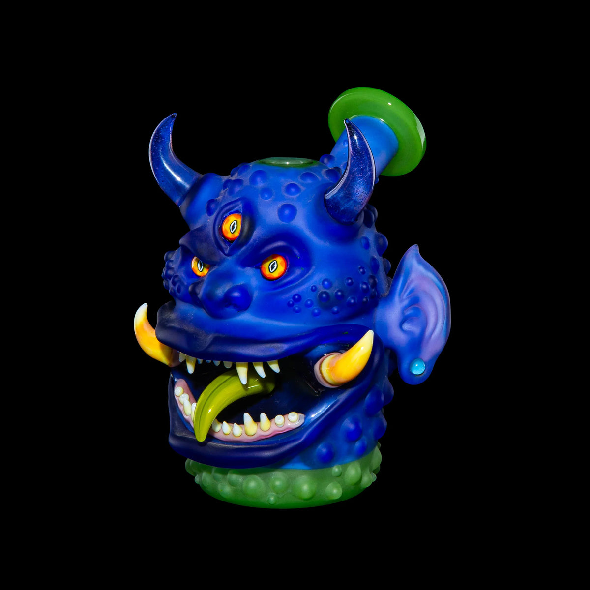 Heady glass monster pipe with horns, three eyes, fangs, and blue detailing on black background