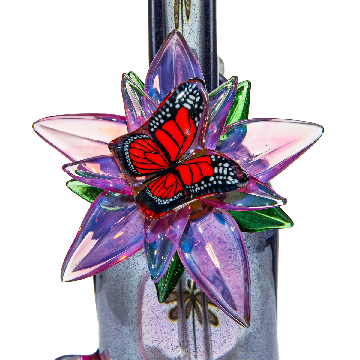 Close-up of a colorful glass flower with a red butterfly accent on a glass pipe.
