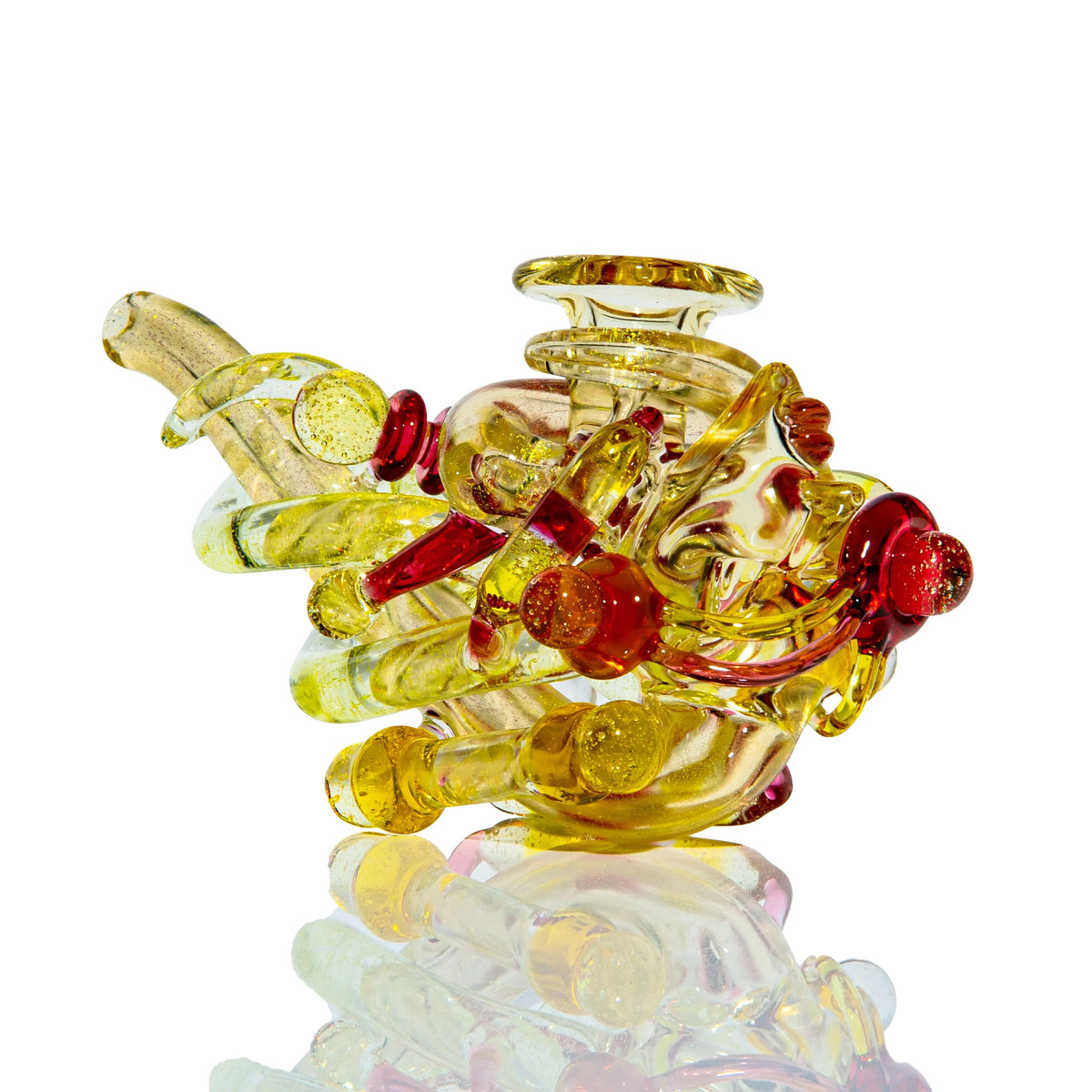 Yellow and orange sculpted glass hand pipe with intricate, artistic design on white background