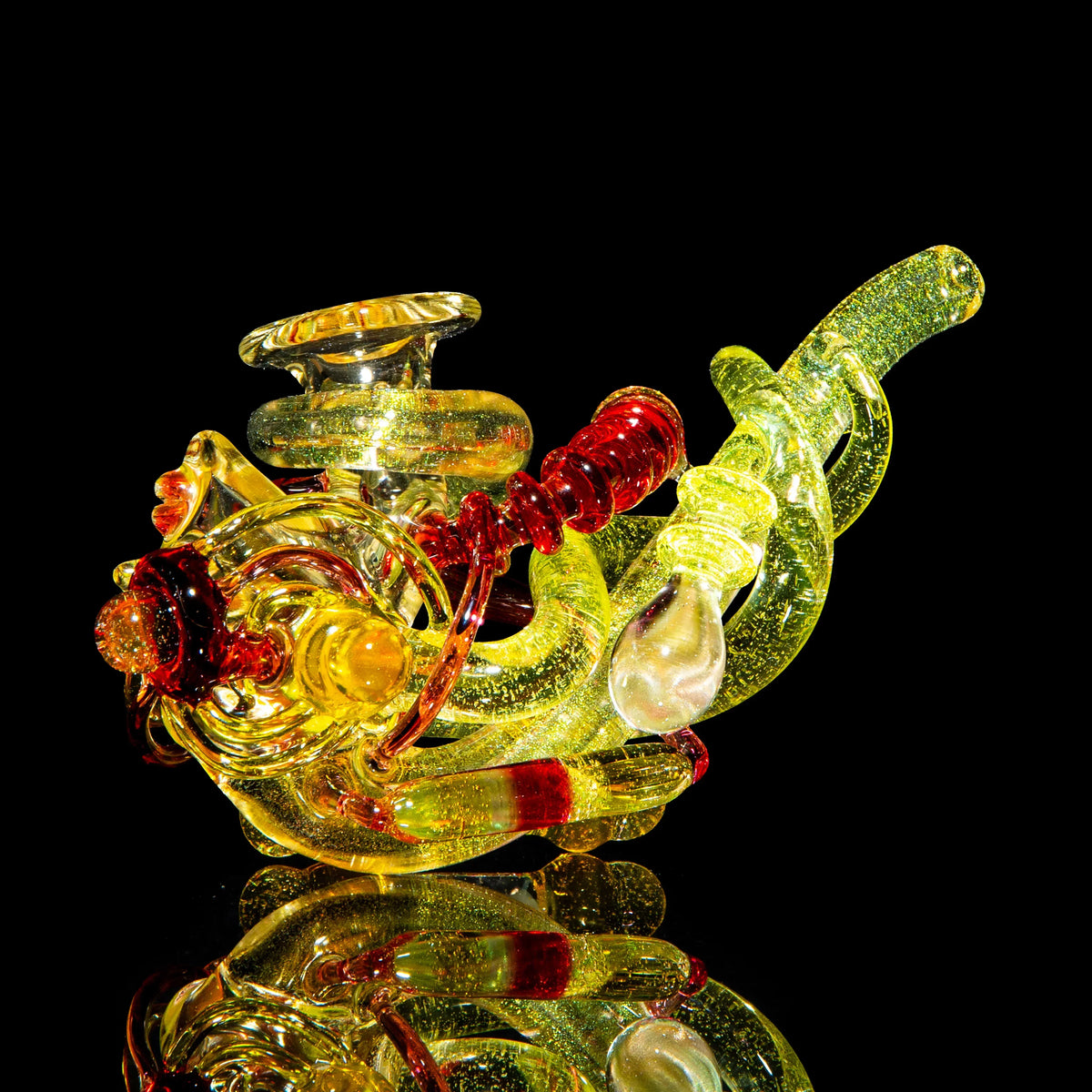 Heady yellow and red glass art pipe with intricate design on black background