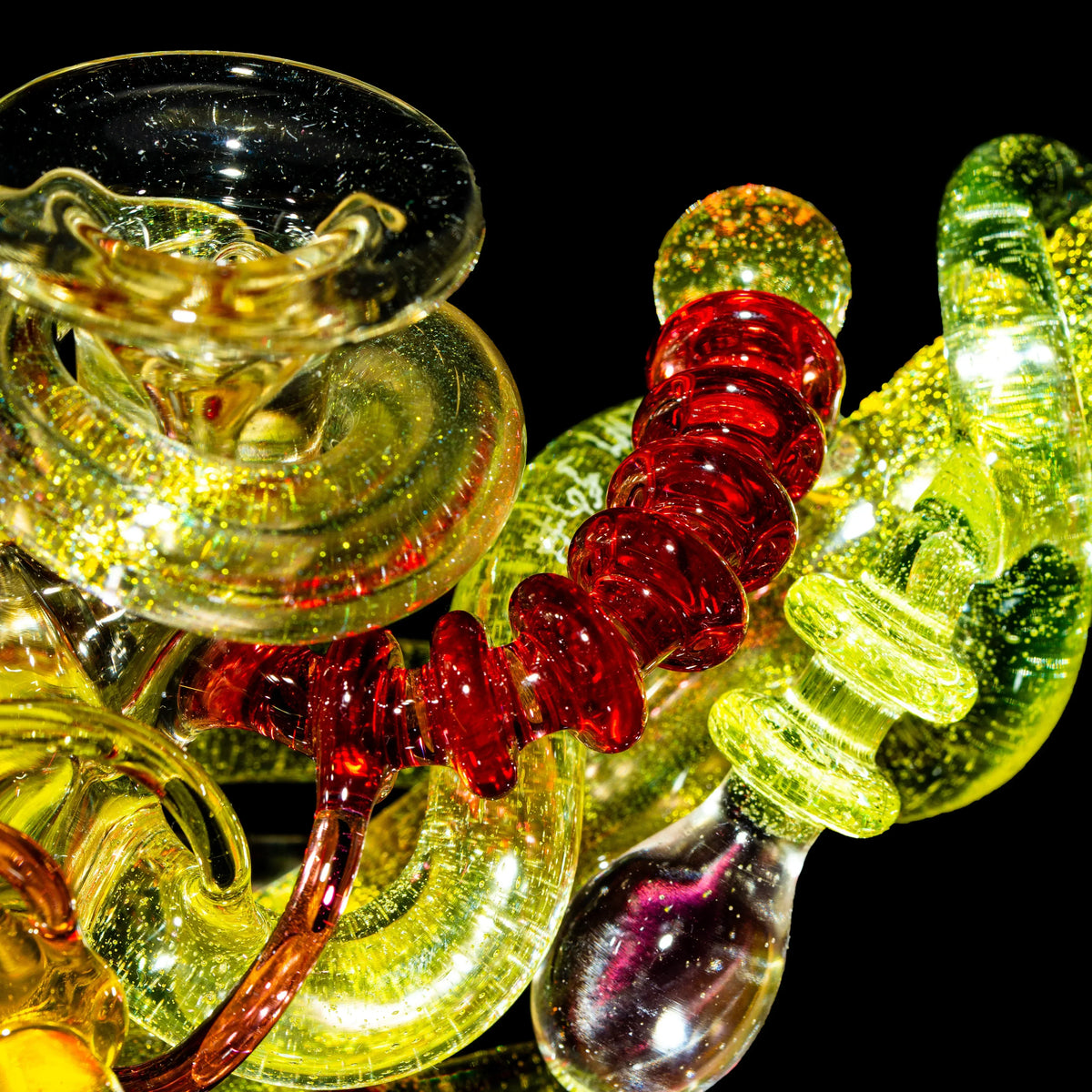 Artistic heady glass pipes with vibrant yellow and red swirls against a black background