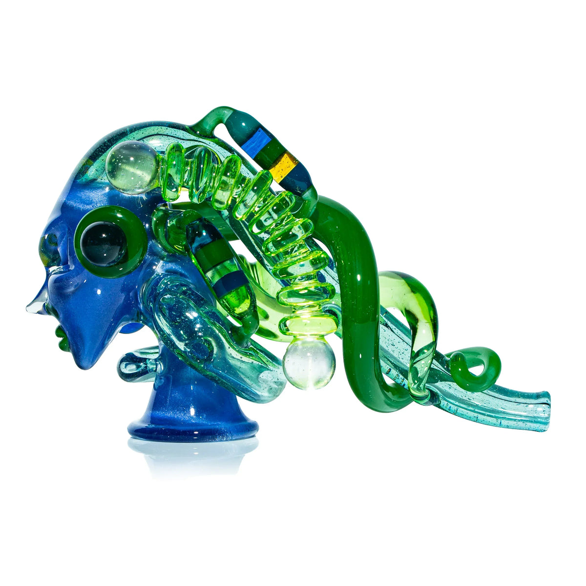 Blue and green glass heady pipe with abstract sculpted details on white background