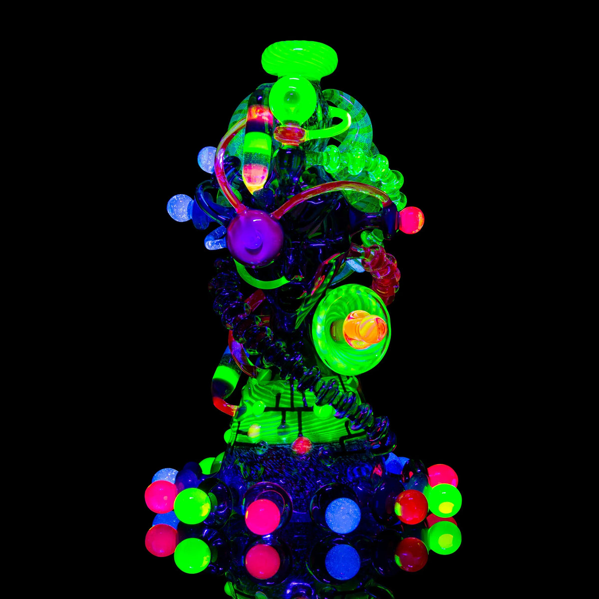 Heady glass art water pipe with vibrant neon UV-reactive details on black background