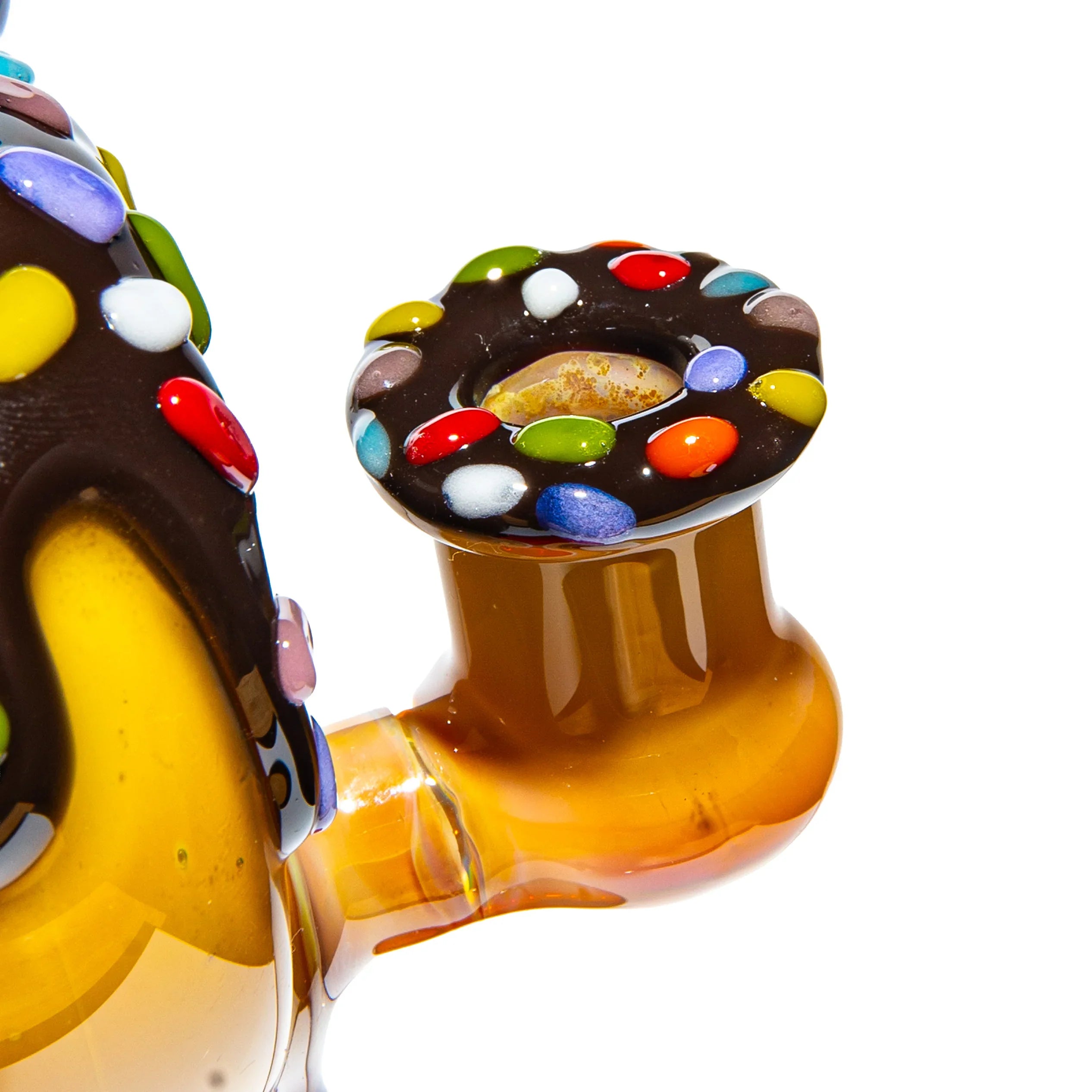 Close-up of a colorful glass pipe with chocolate donut and candy sprinkle design.