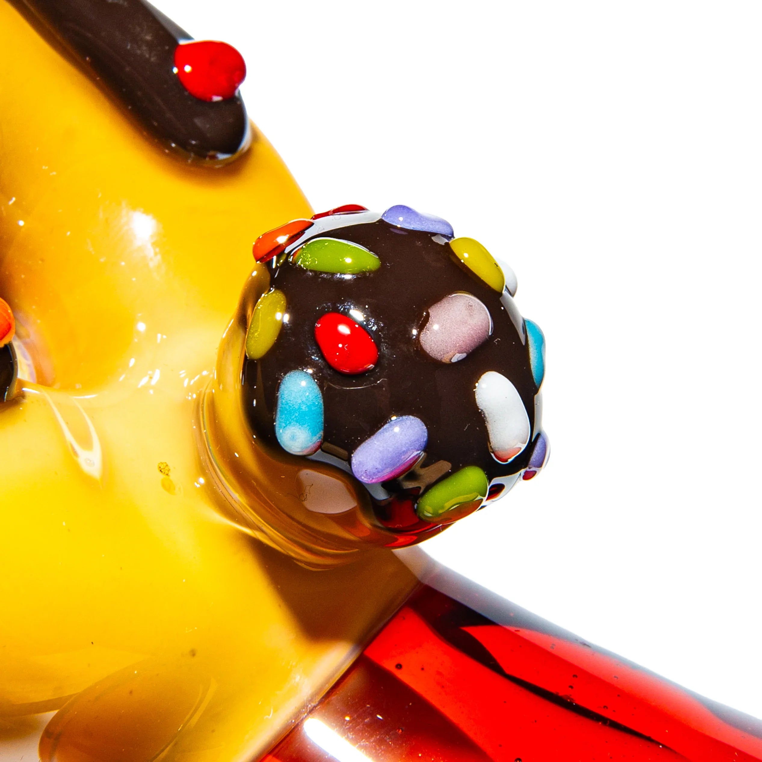 Close-up of colorful glass hand pipe with chocolate and candy sprinkle design