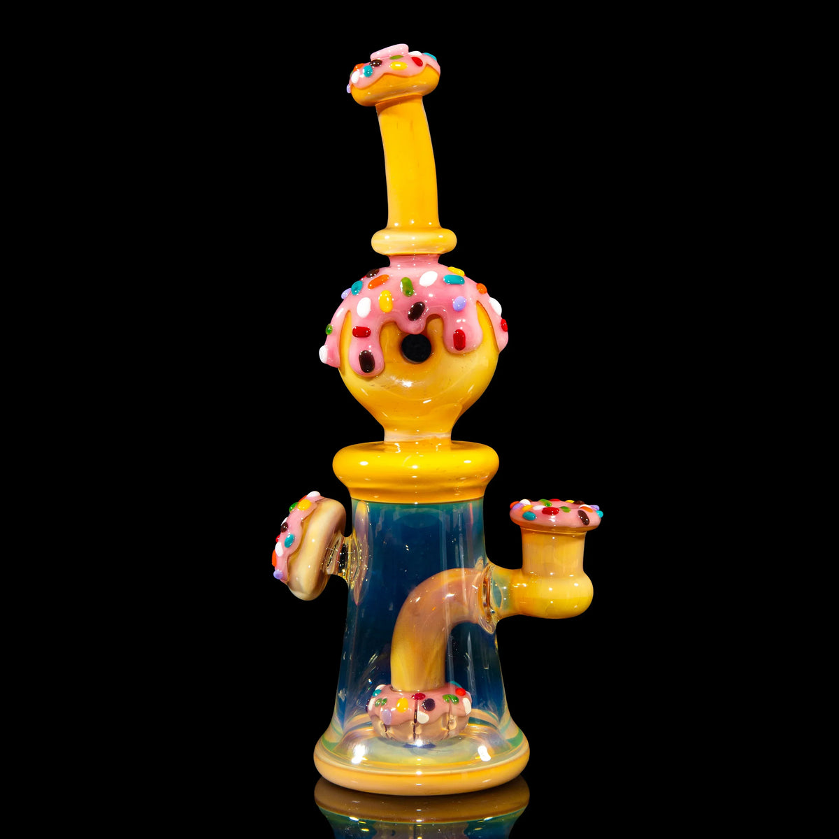 Yellow donut-themed glass water pipe with pink frosting and colorful sprinkles on black background