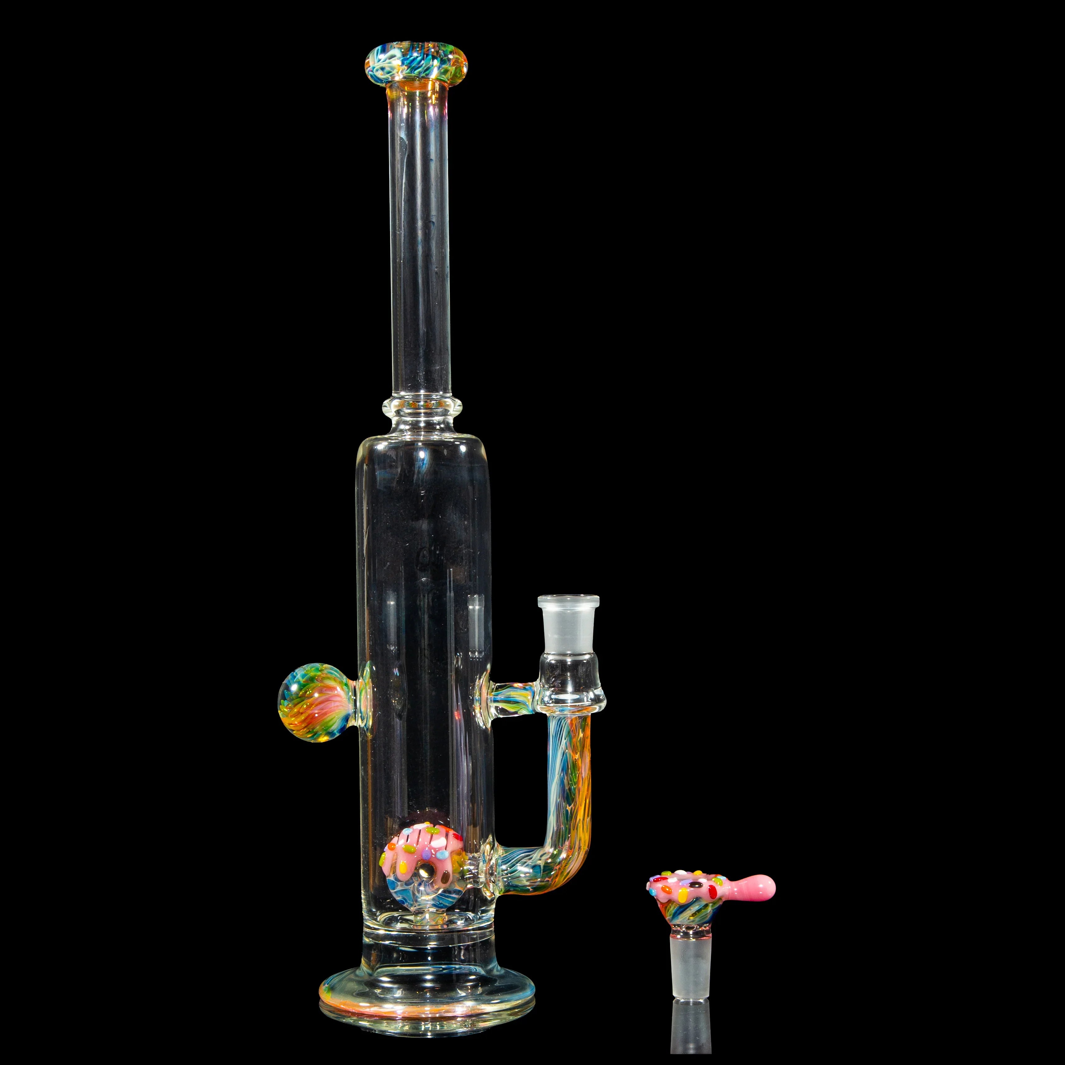 Colorful glass water pipe with donut-themed bowl and accents on a black background