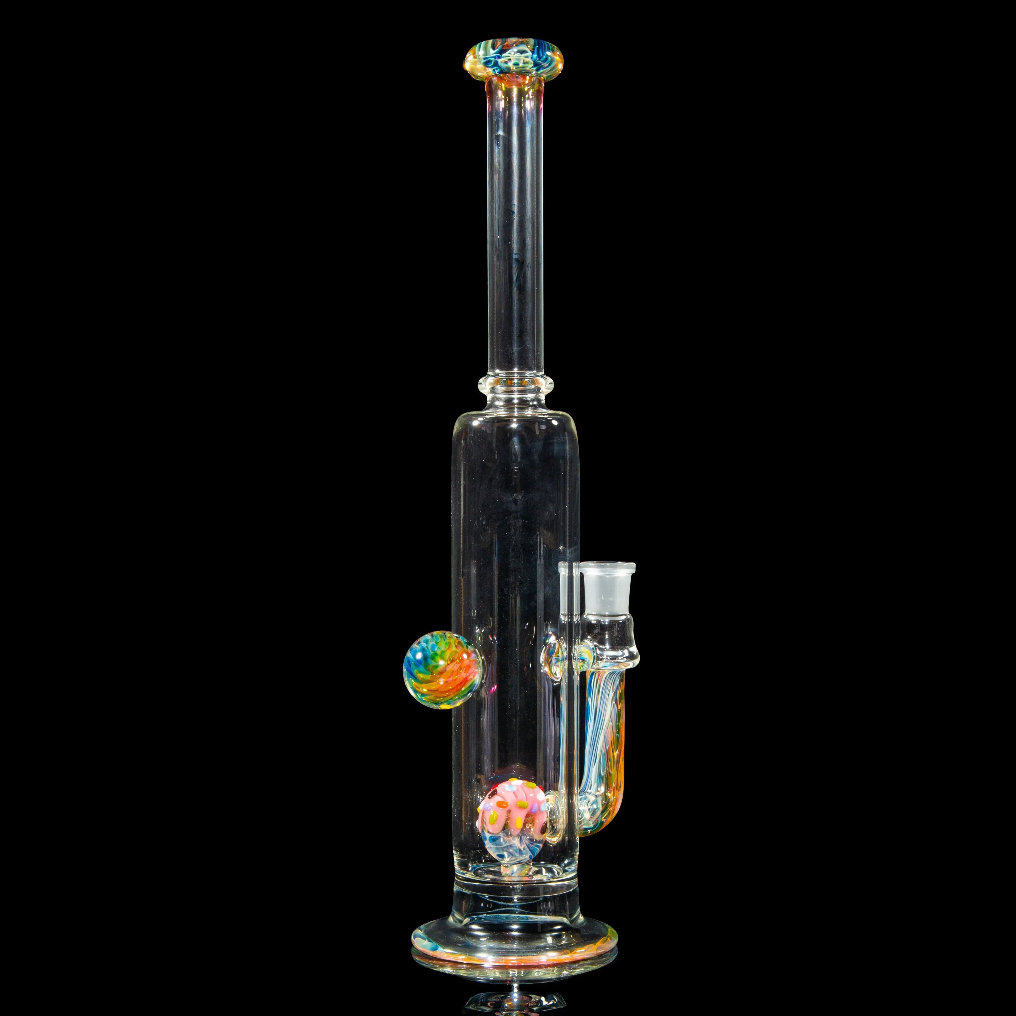 Clear heady glass water pipe with colorful marble accents on black background