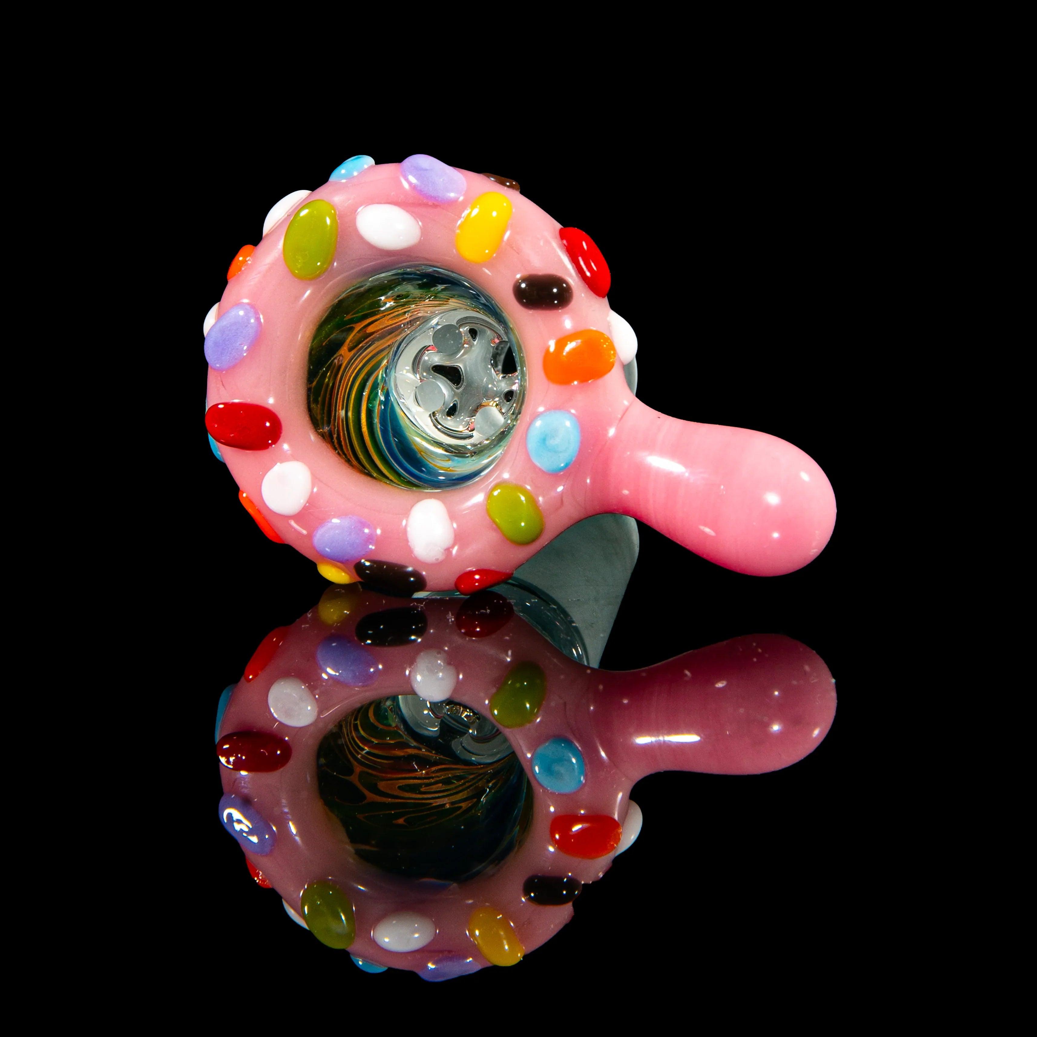 Pink glass hand pipe with colorful candy-like accents on a glossy black background