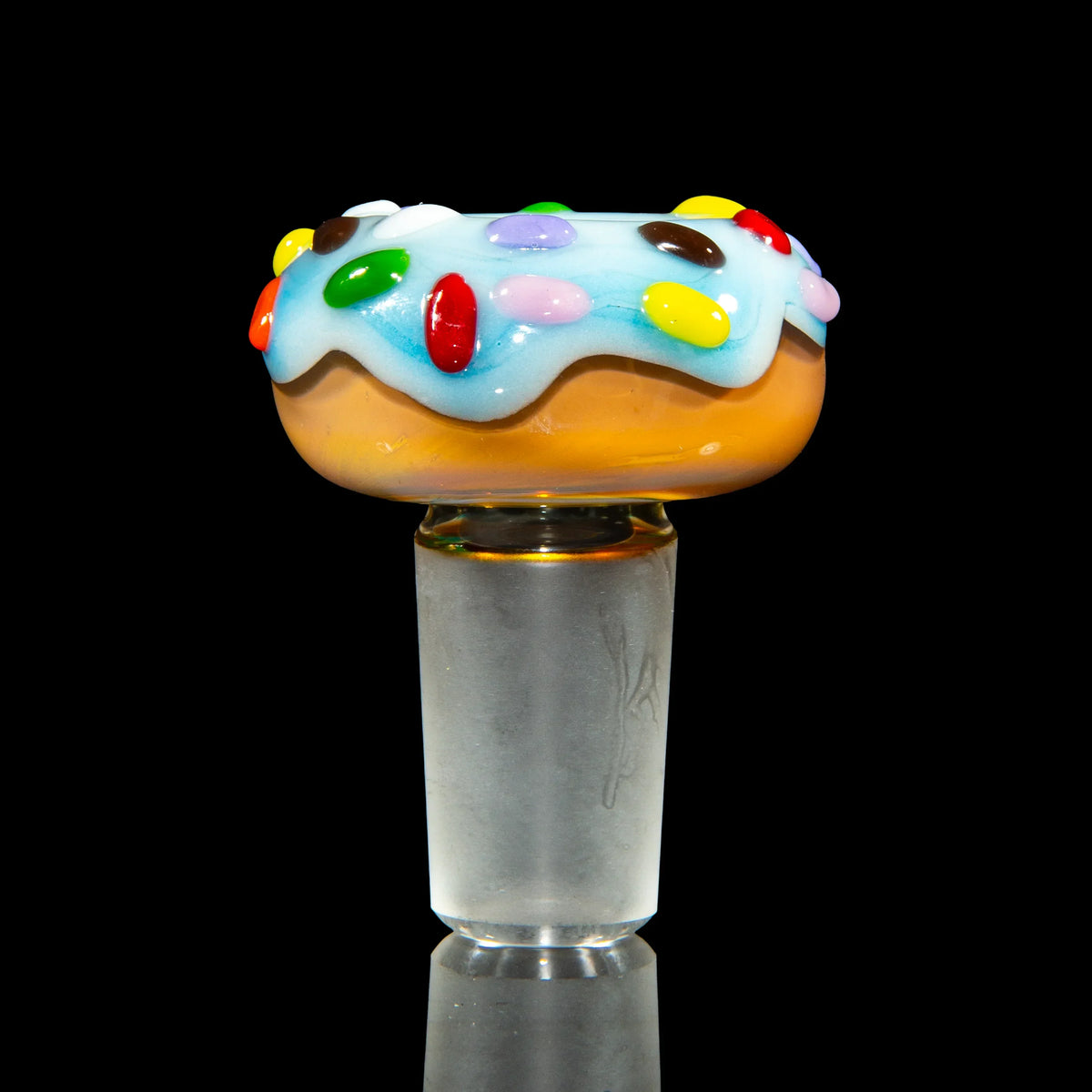 Colorful glass bowl piece shaped like a donut with blue icing and candy accents