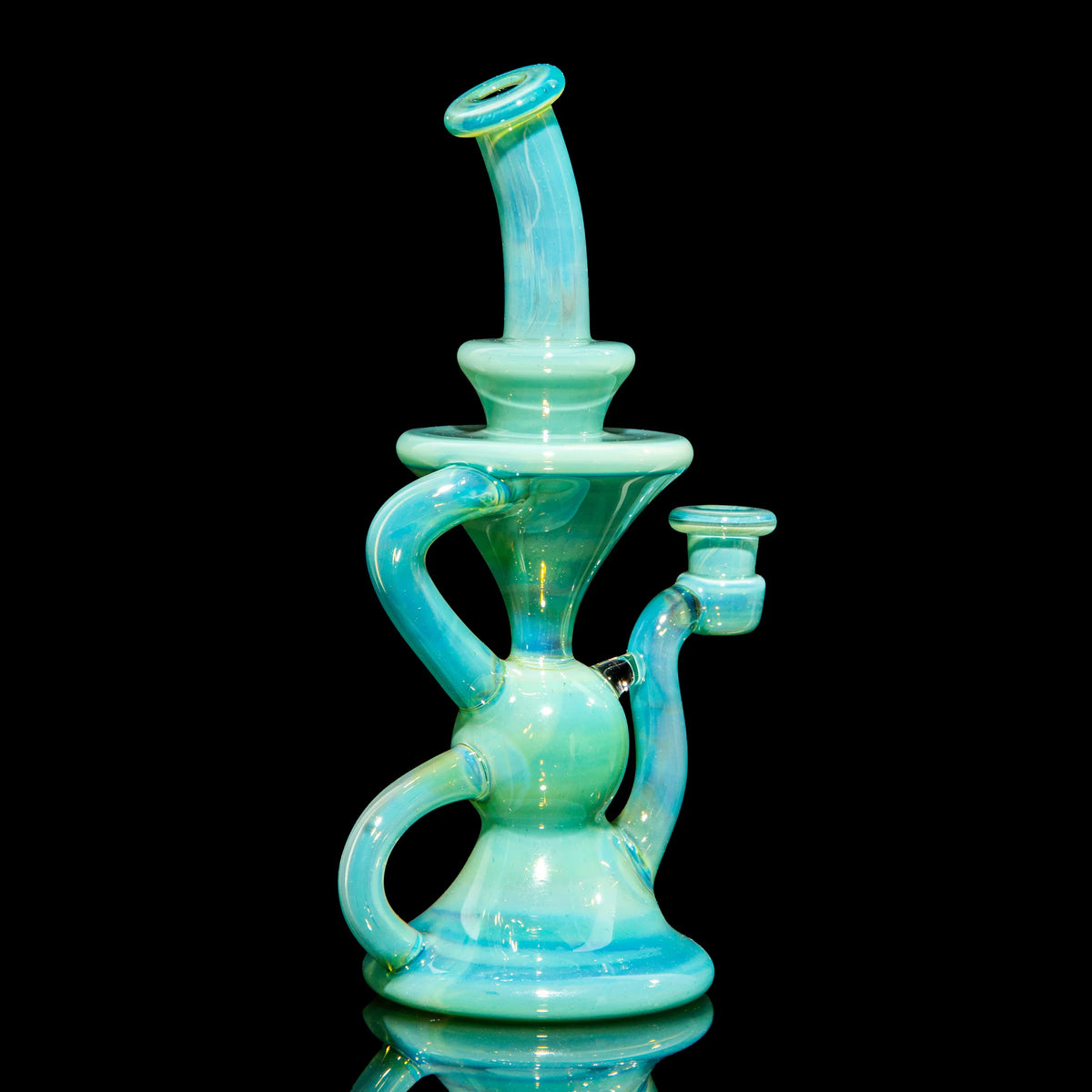 Aqua blue heady glass water pipe with intricate recycler design on black background.