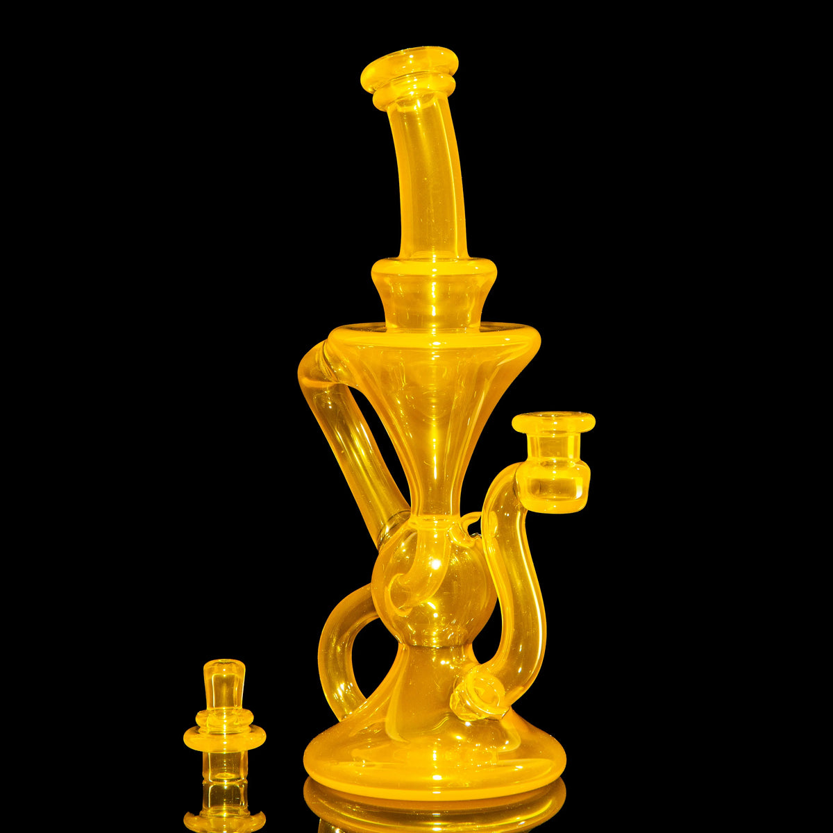 Yellow glass water pipe with intricate design on black background