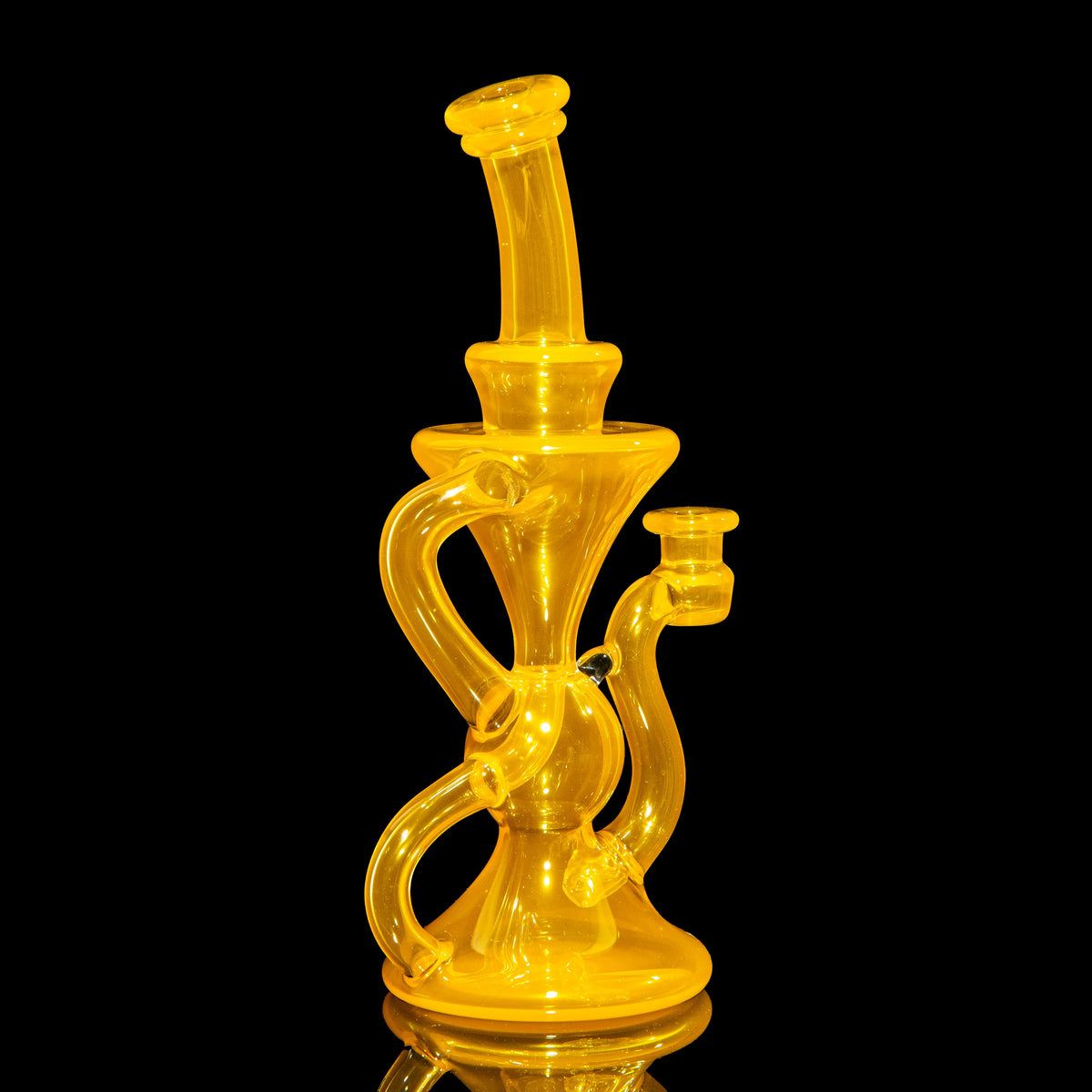 Yellow glass water pipe with intricate recycler design on black background