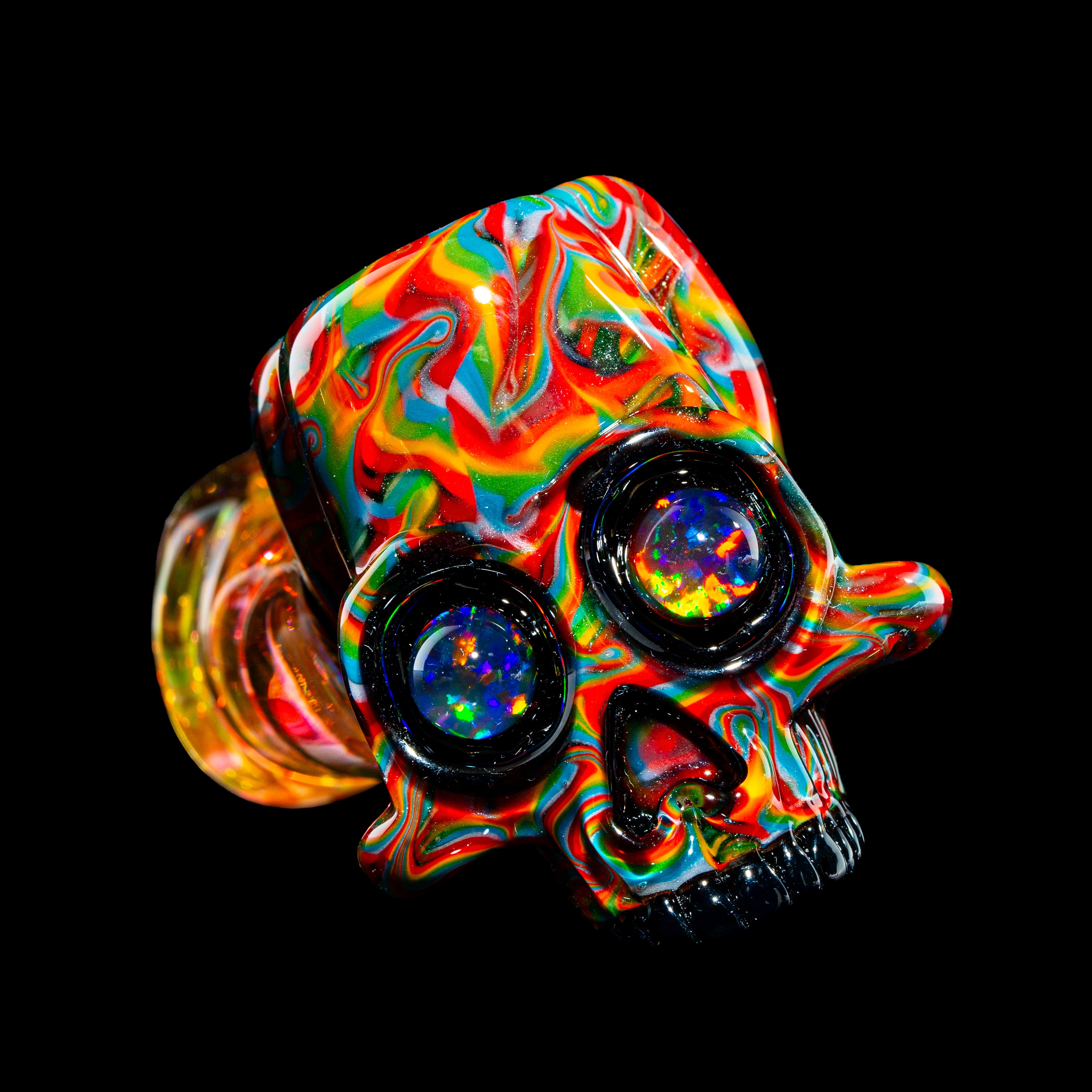 Colorful heady glass skull carb cap with opal inlaid eyes on black background