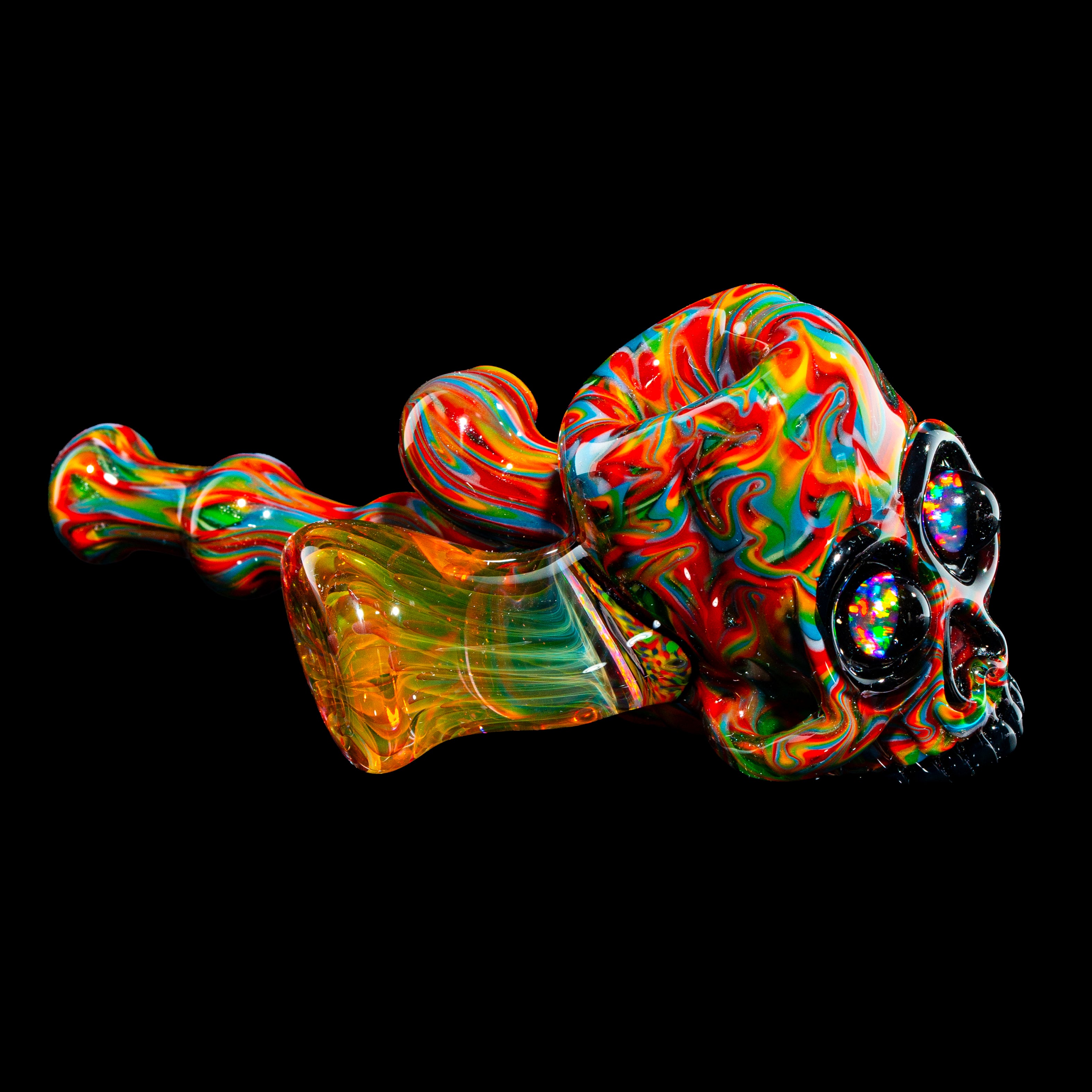 Colorful glass pipe shaped like a skull with vibrant, swirling patterns on black background