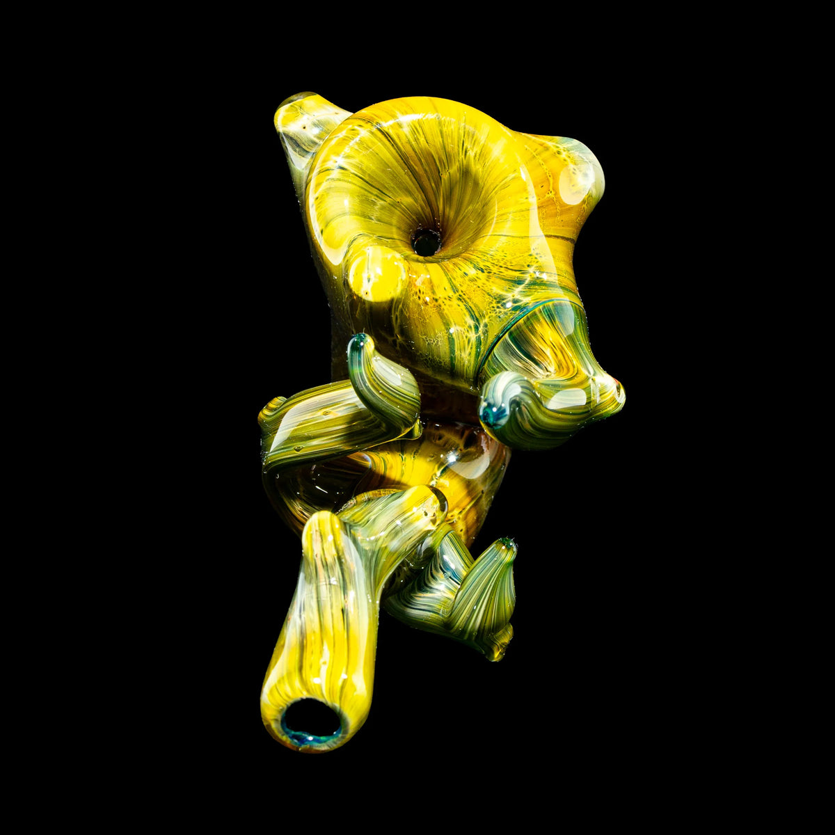 Handcrafted yellow and green glass pipe with unique swirling patterns on a black background.