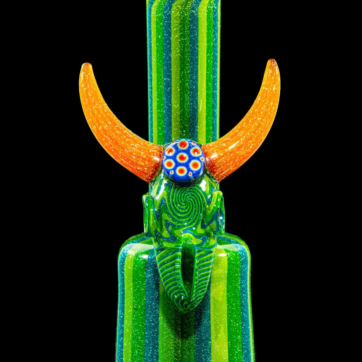 Colorful glass art bong with green swirls and orange horns on a black background