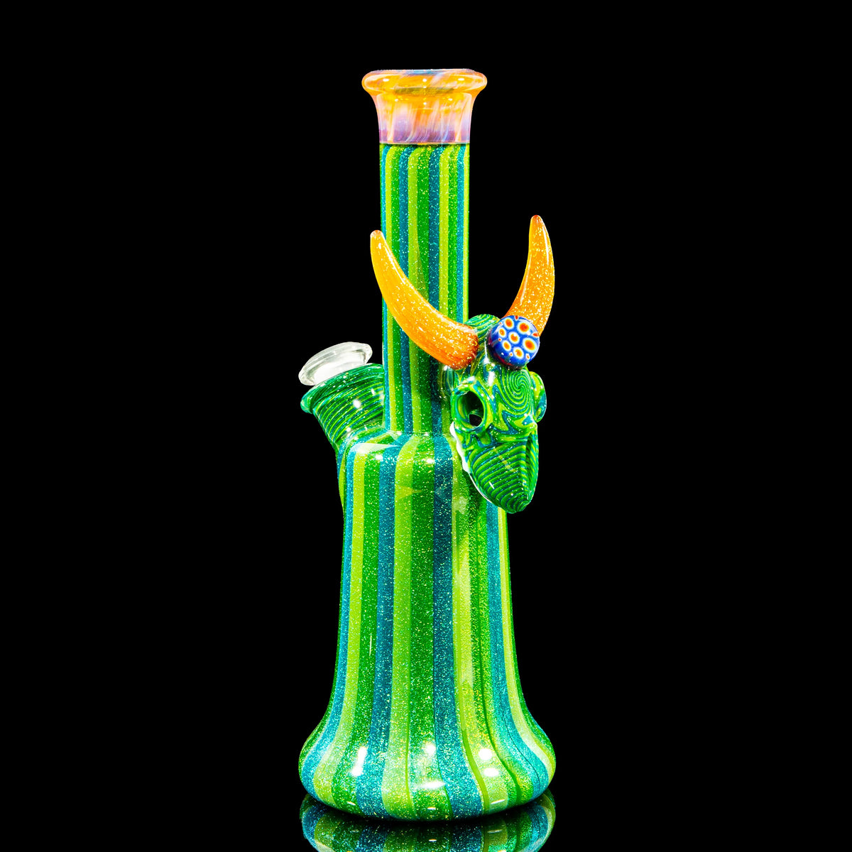 Heady glass water pipe with green glitter stripes and orange horned bull design on black background