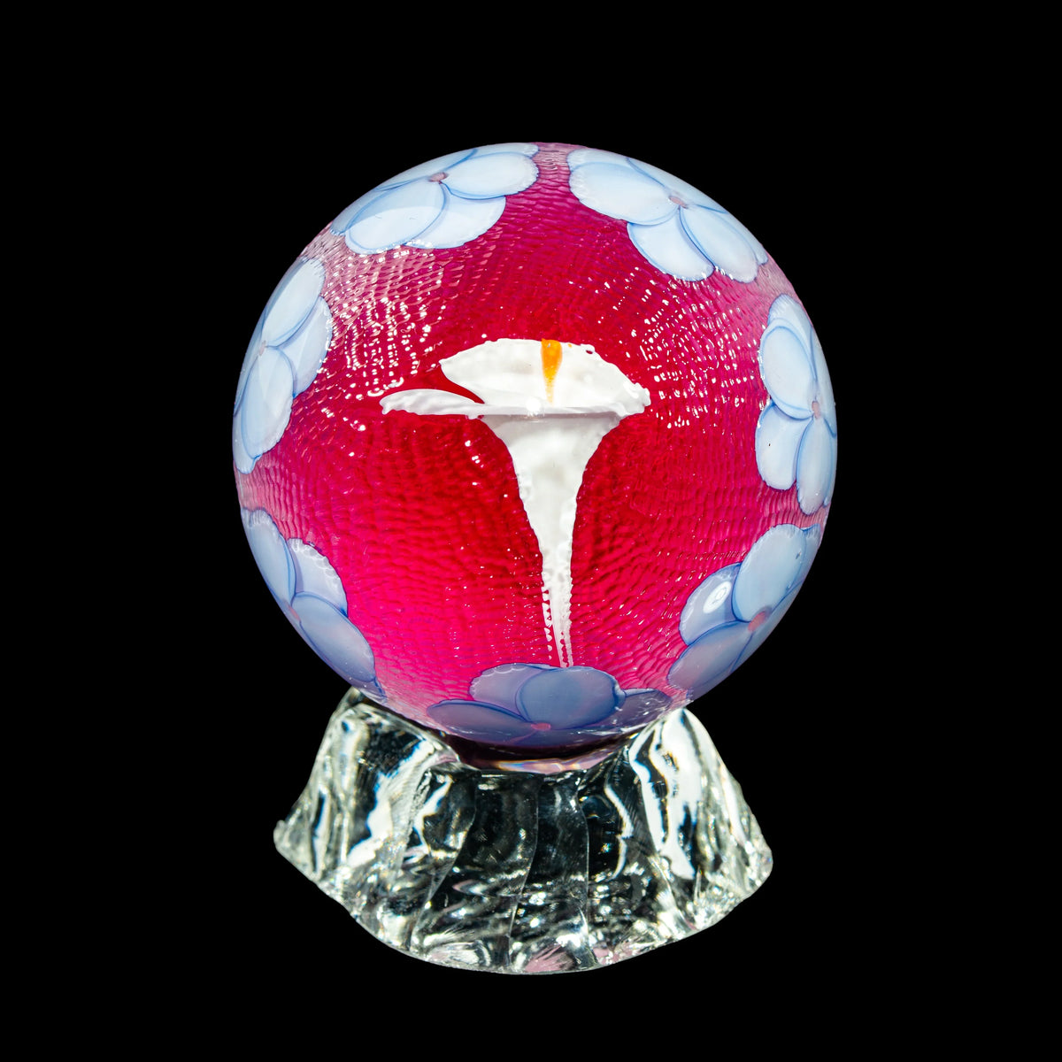 Handcrafted glass orb with blue floral accents and white flower design on acrylic base