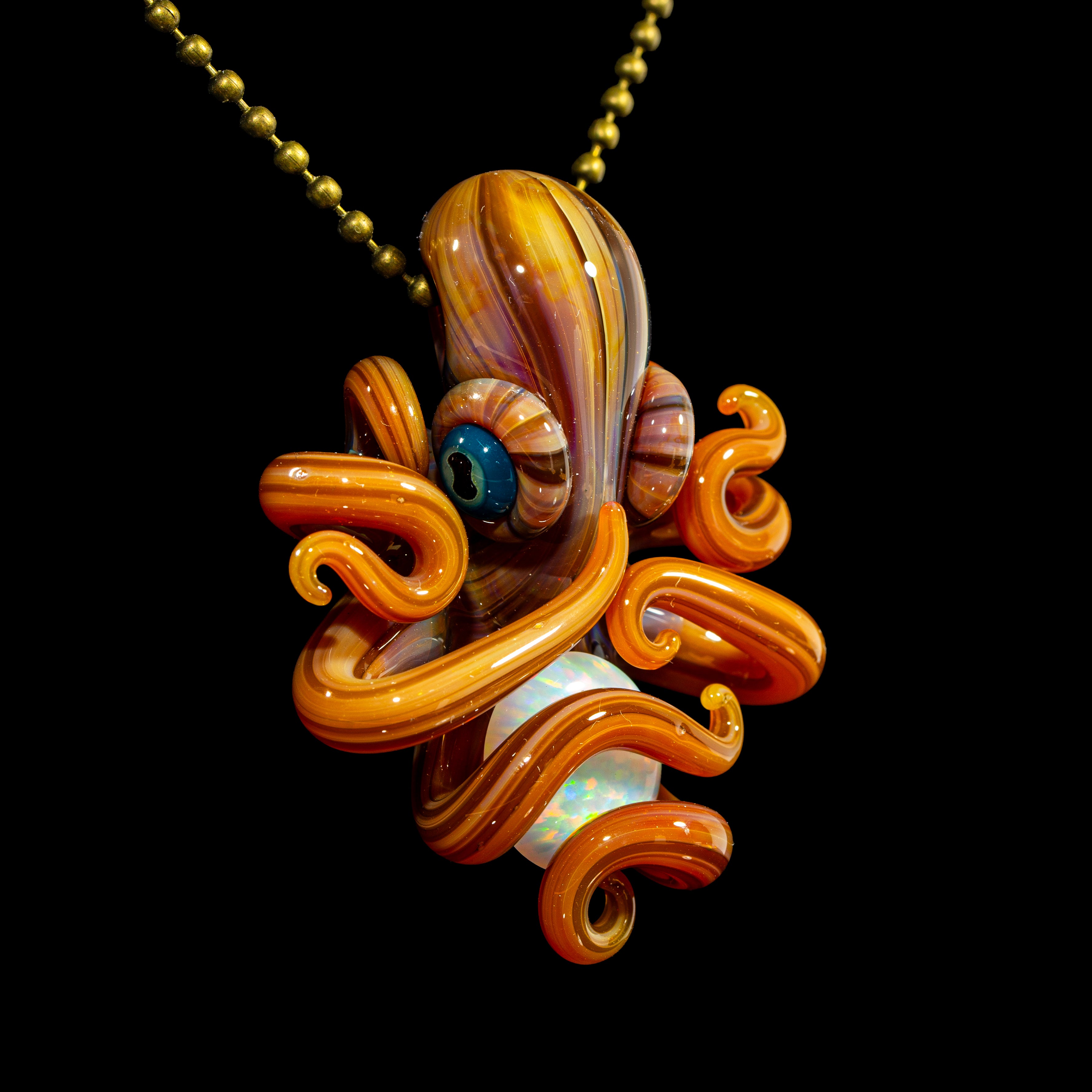 Handmade glass octopus pendant with orange swirls and opal centerpiece on gold chain