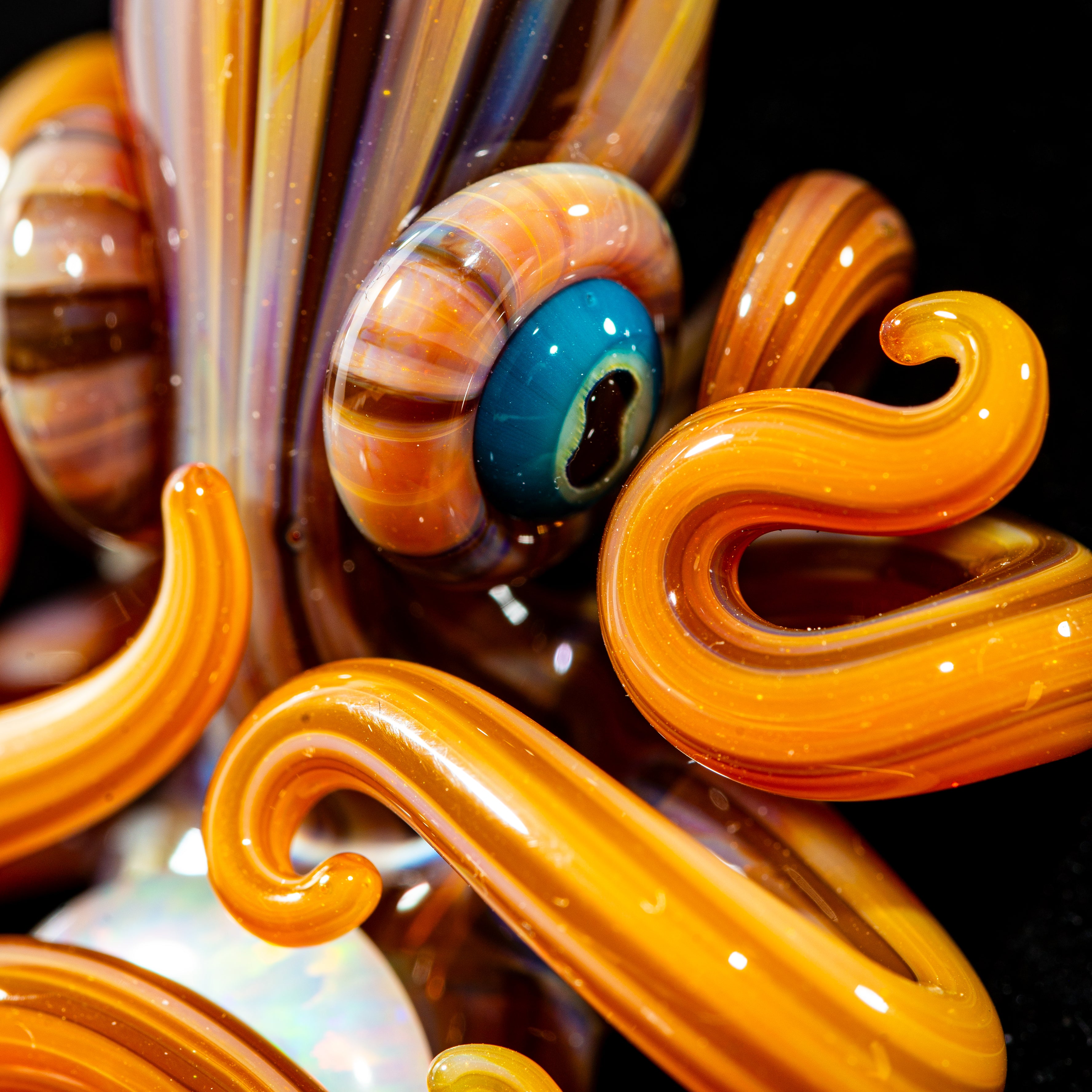Close-up of intricate orange glass octopus art with swirling tentacles and vivid blue eye