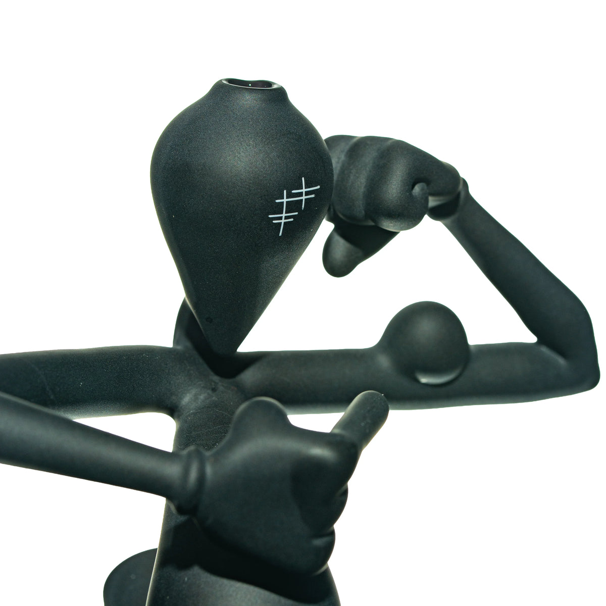 Matte black glass figurine with abstract humanoid shape and etched marks on face, glass art.