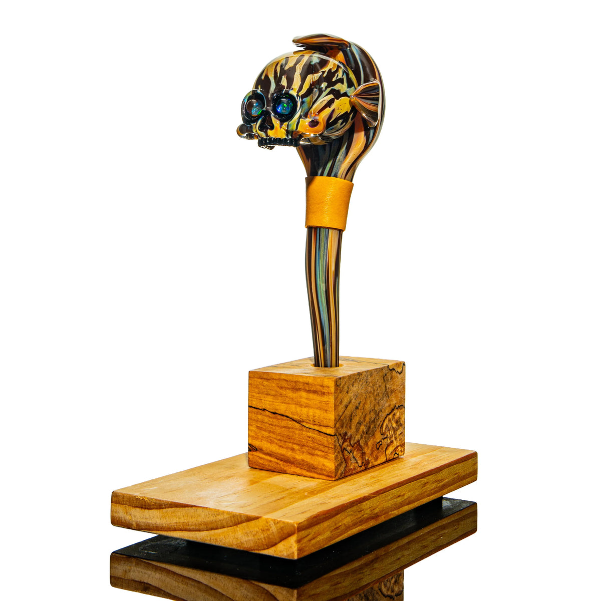 Artistic glass pipe with skull and fish design on wooden display stand, premium glassware