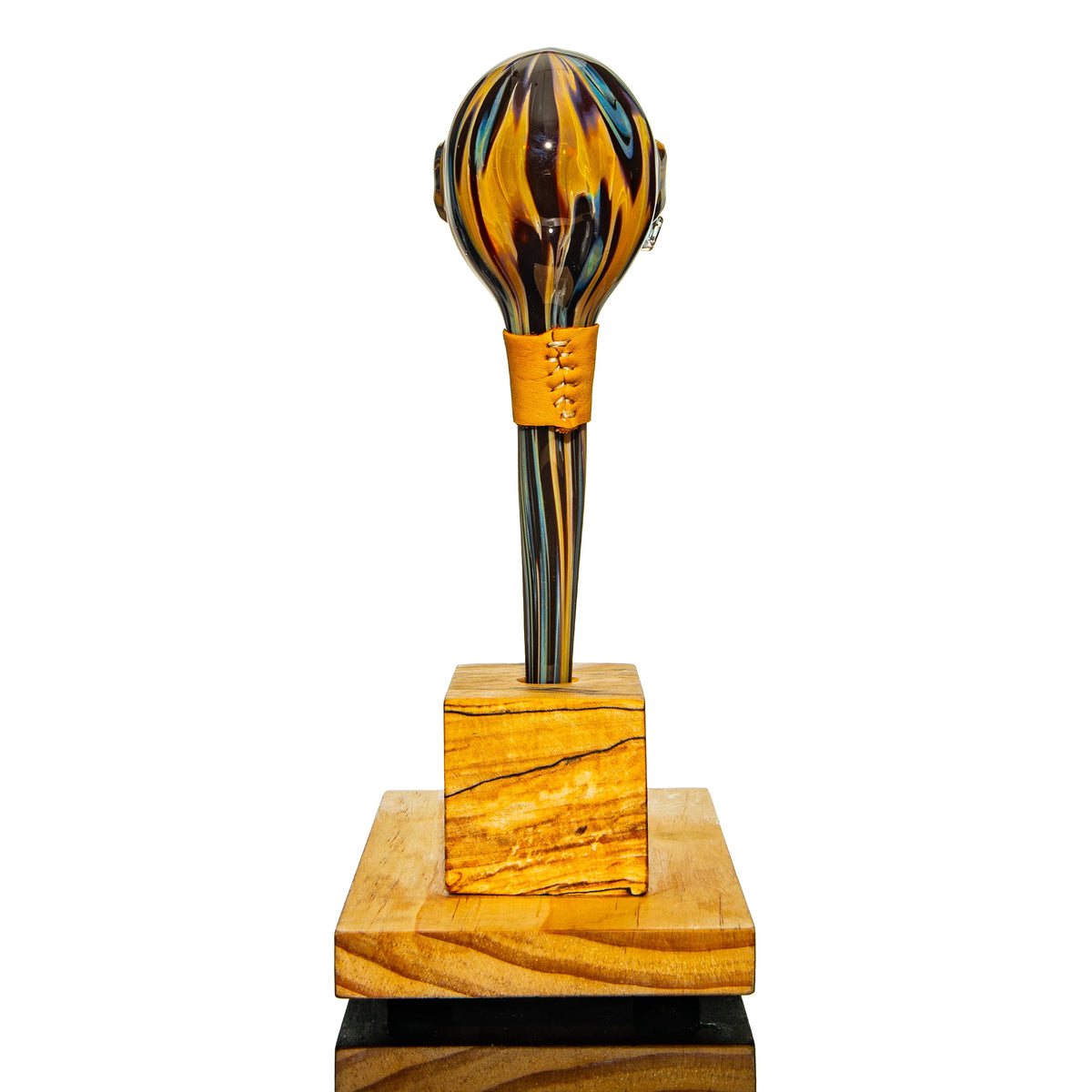 Hand-blown glass sculpture with colorful swirls on wooden display stand