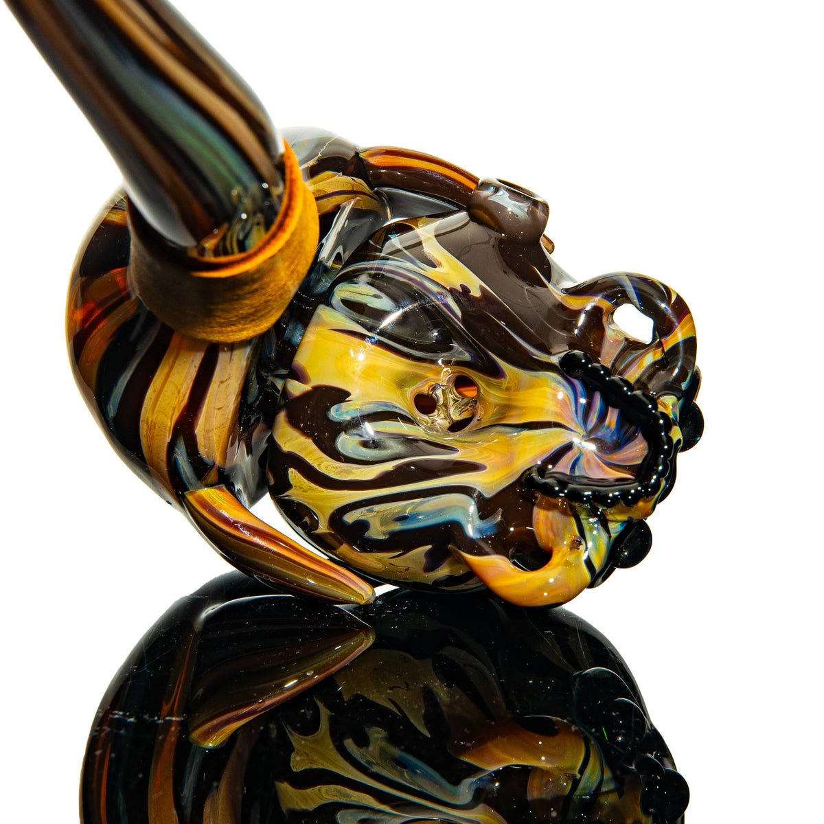 Colorful glass pipe with intricate swirled patterns on reflective black surface