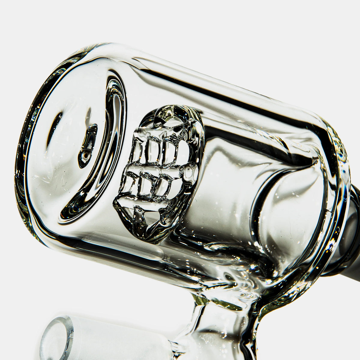Close-up of clear glass water pipe percolator with detailed grid diffuser on white background