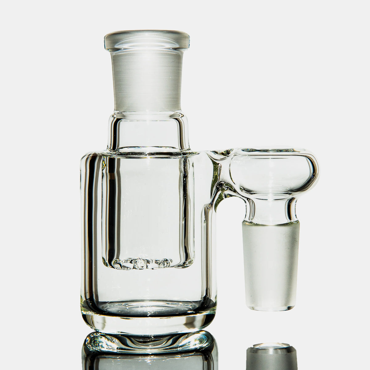 Clear glass ash catcher with percolator for water pipe on white background