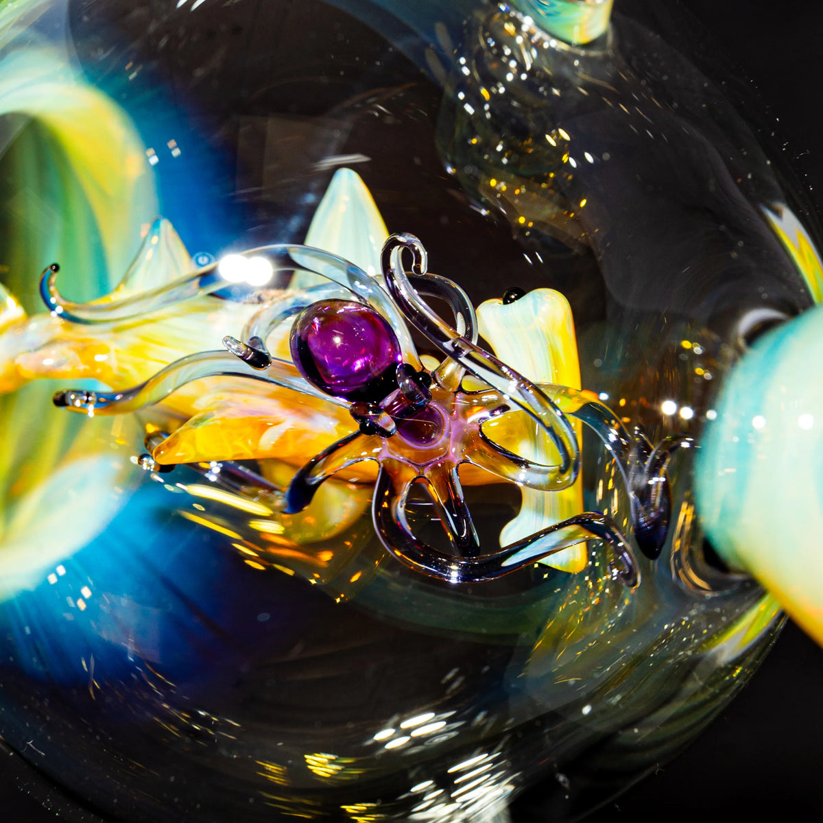 Close-up of a colorful blown glass octopus sculpture with vibrant yellow and blue accents