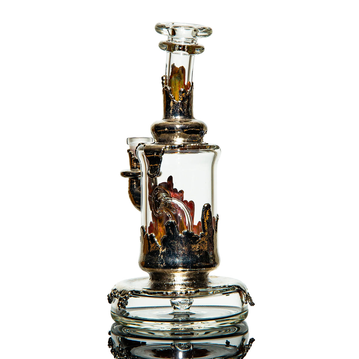 Heady glass water pipe with metallic accents and intricate flame-like details, isolated on white.