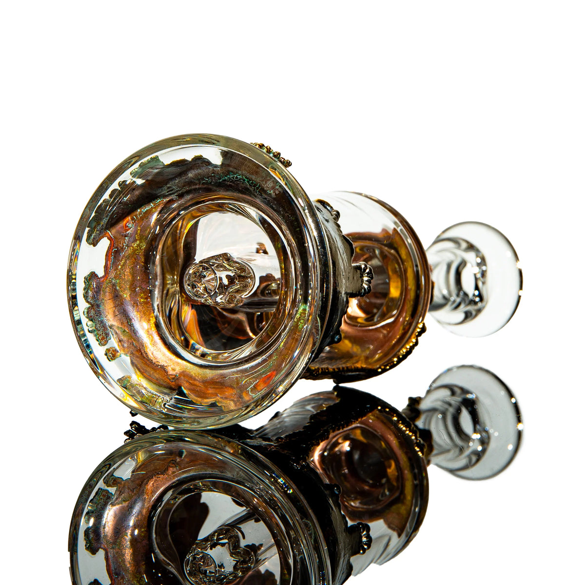 Handcrafted heady glass water pipe with iridescent colors and detailed accents, reflected on glass.