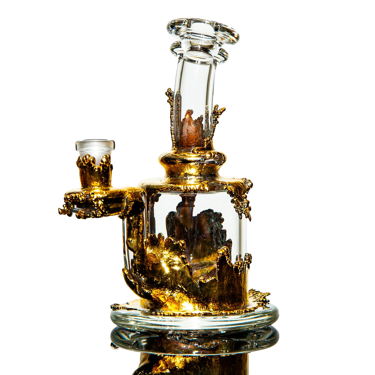 Heady glass water pipe with intricate gold accents and clear chamber on white background