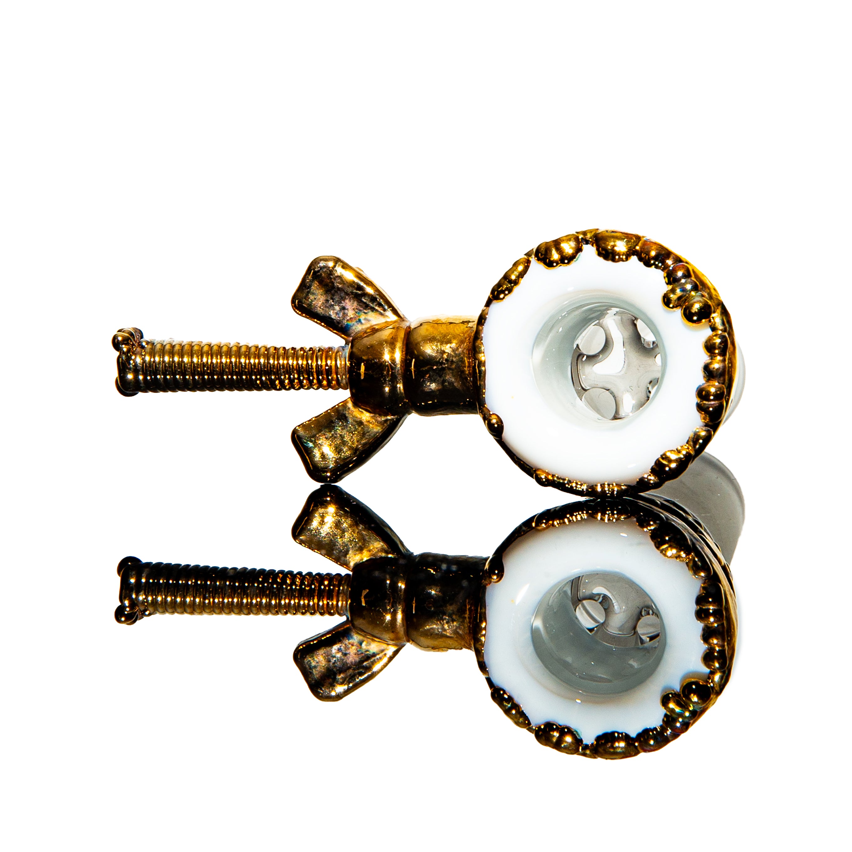 Gold and white glass bowl with intricate detailing, reflected on a glossy surface
