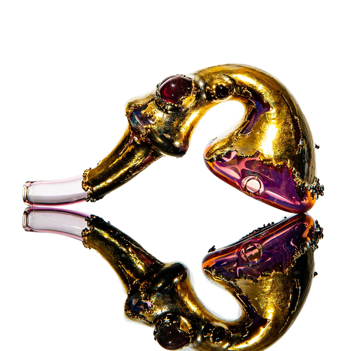 Heady gold and purple glass hand pipe with artistic design and reflection on white background.