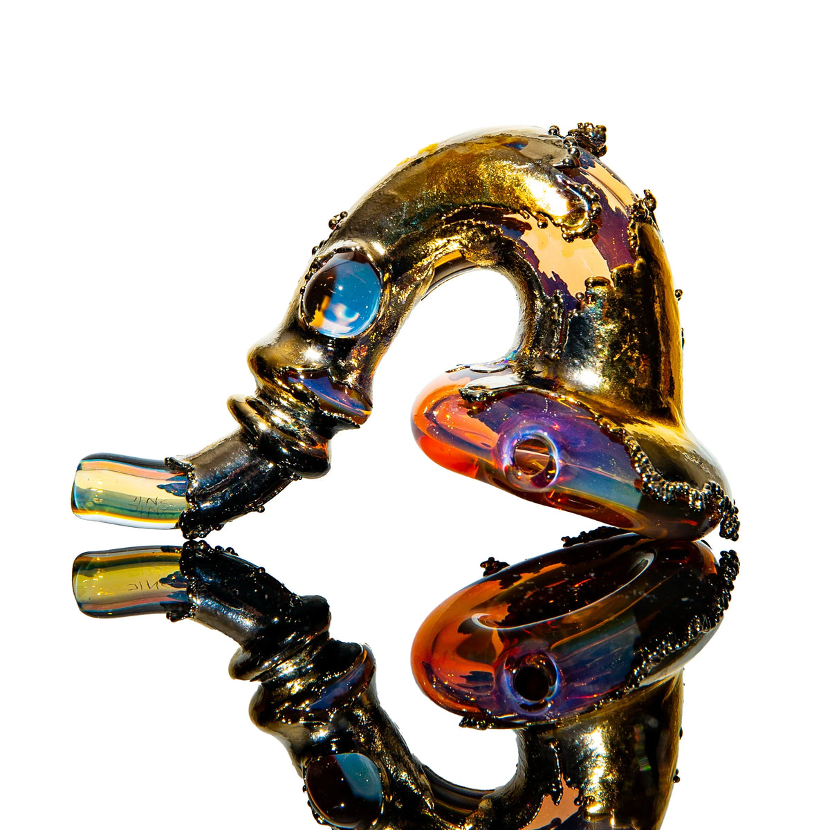Heady glass pipe with iridescent gold and orange details, displayed on reflective surface