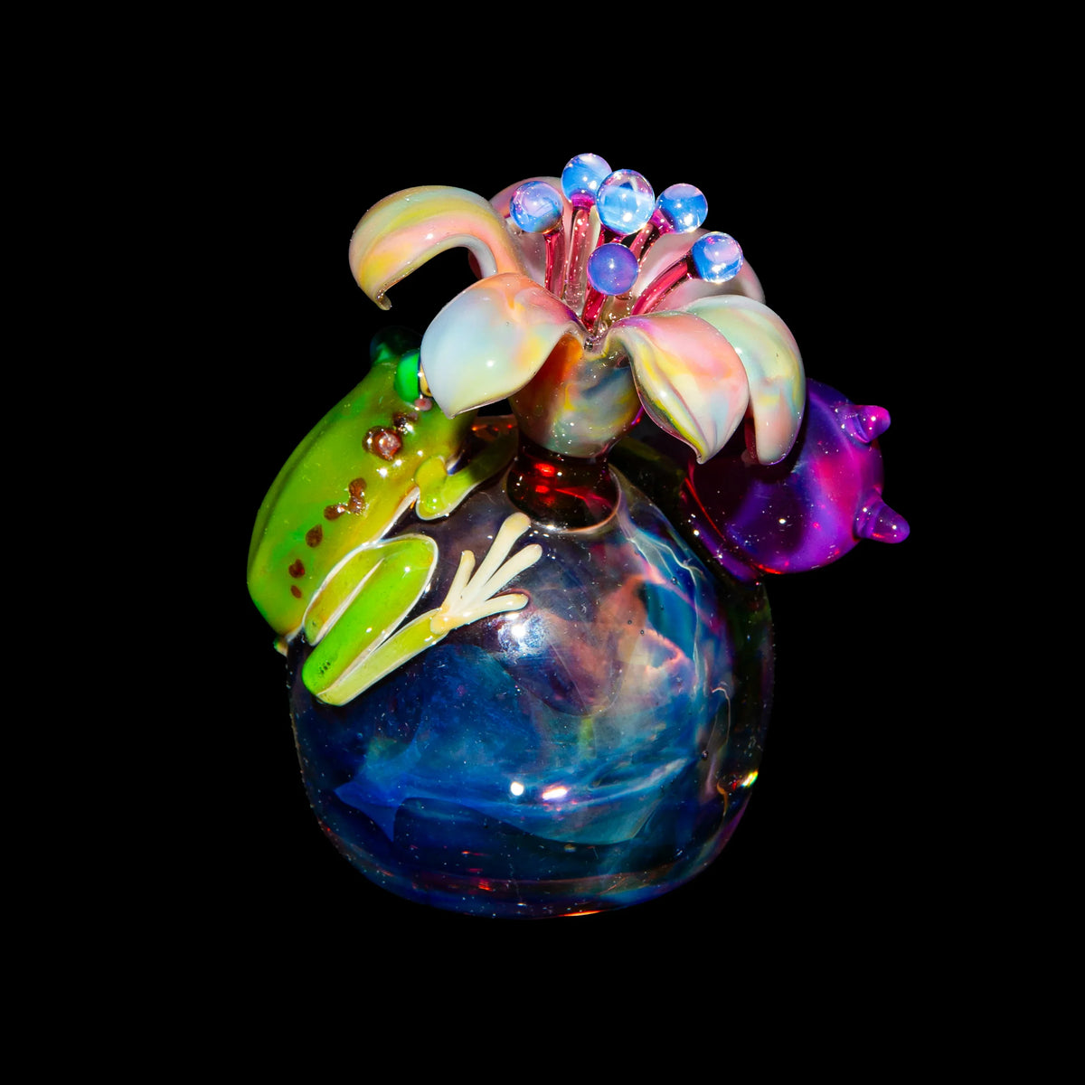 Colorful glass art piece with a green frog and flower detail against a black background