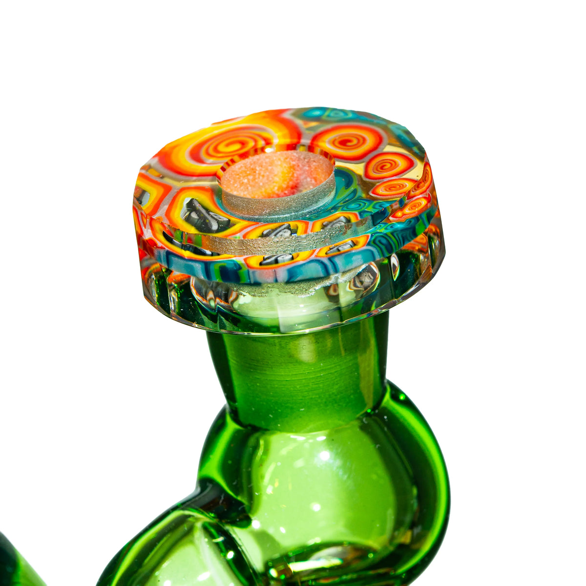 Close-up of heady glass rig with vibrant, multicolored, psychedelic-patterned carb cap