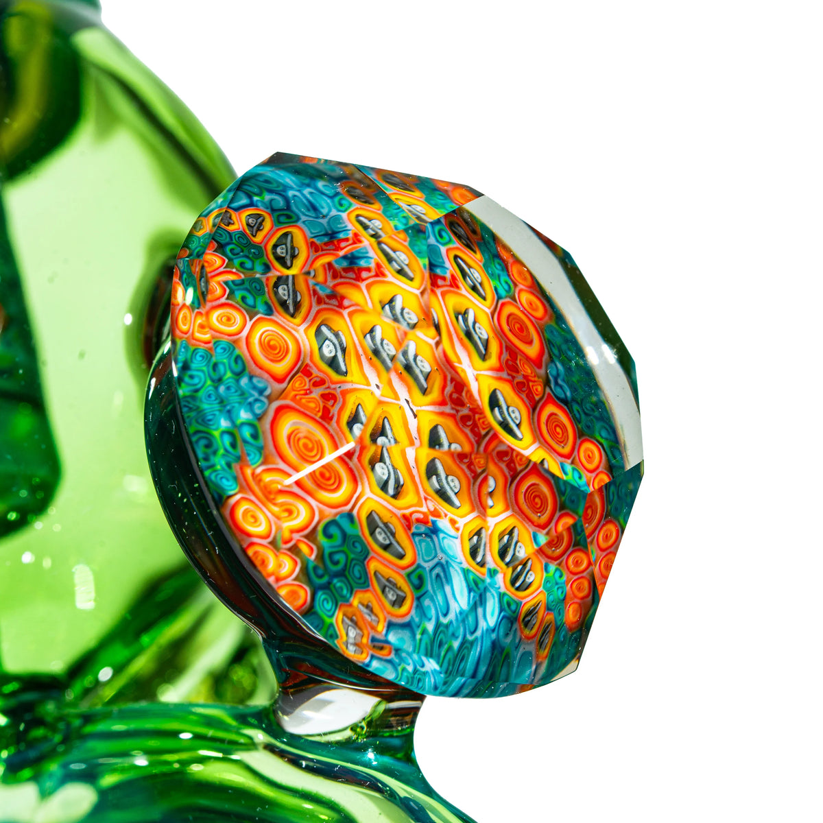 Close-up of colorful heady glass art with geometric patterns and green accents