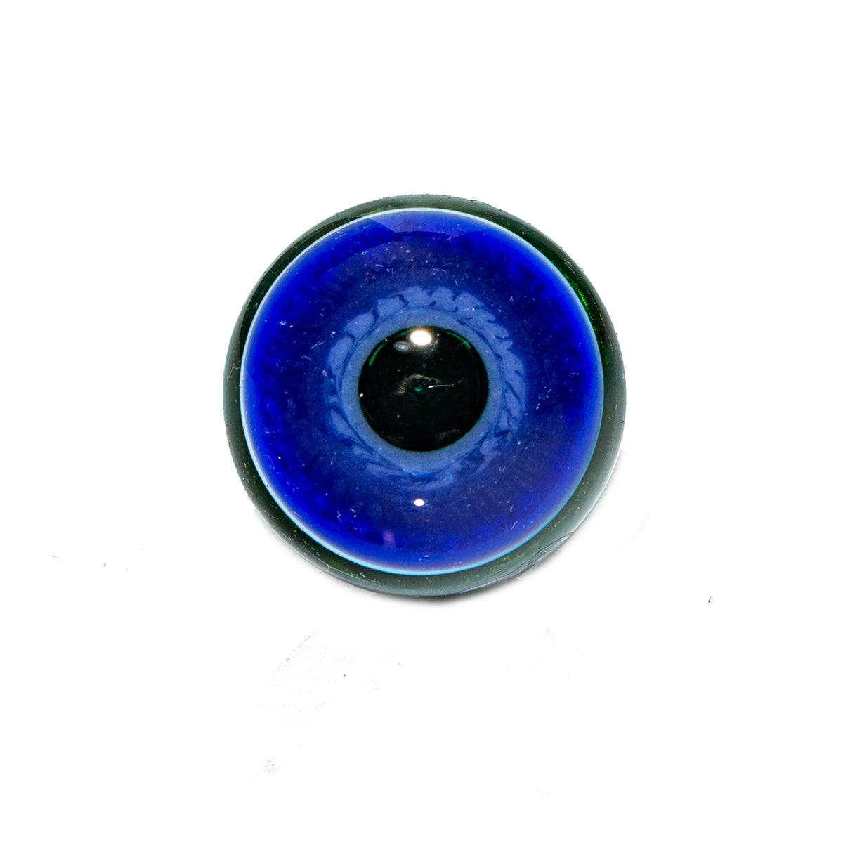 Close-up of a blue glass marble with a black core on white background