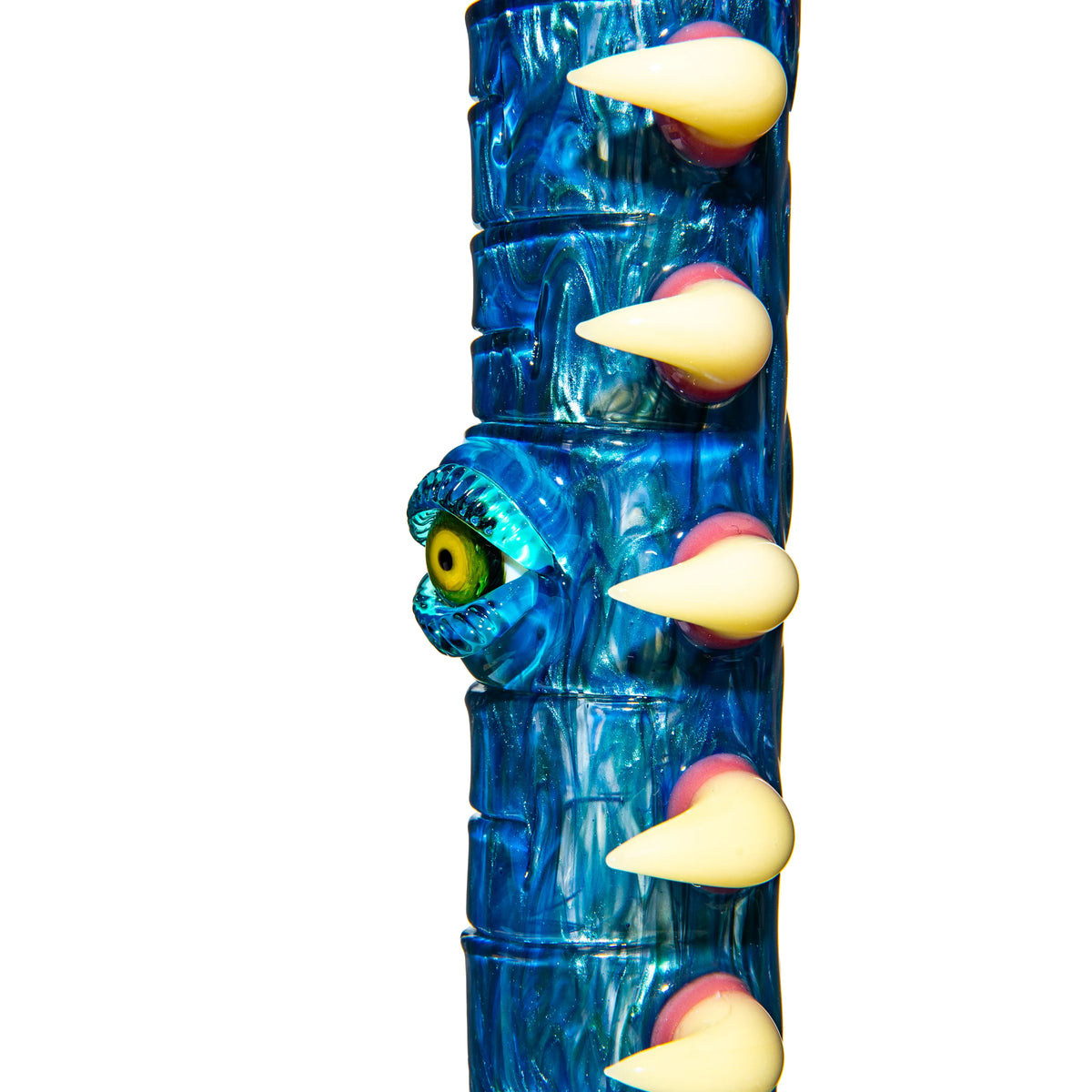 Close-up of a blue glass water pipe with a sculpted yellow eyeball and white spikes