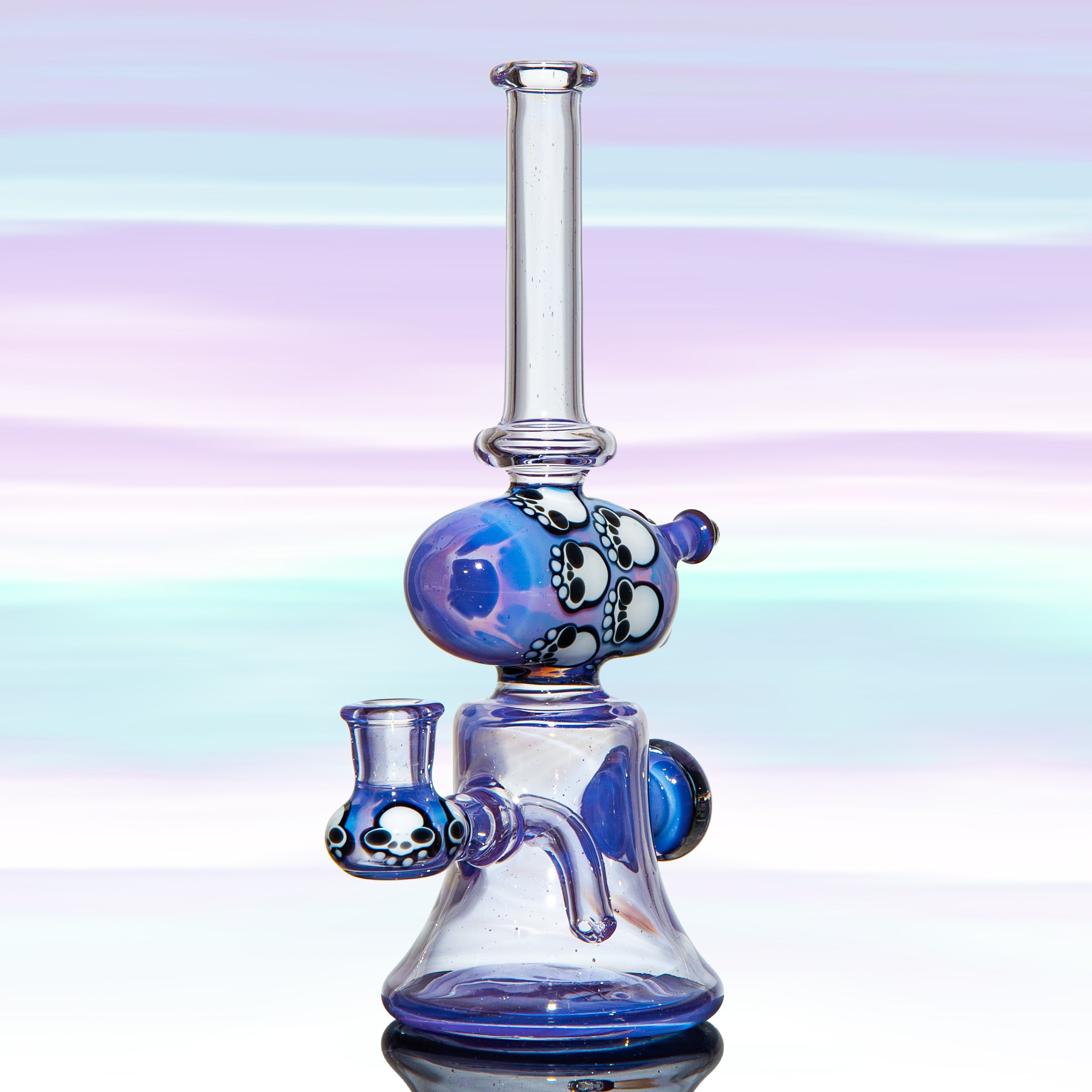 Blue and clear glass water pipe with skull pattern accents on a pastel background